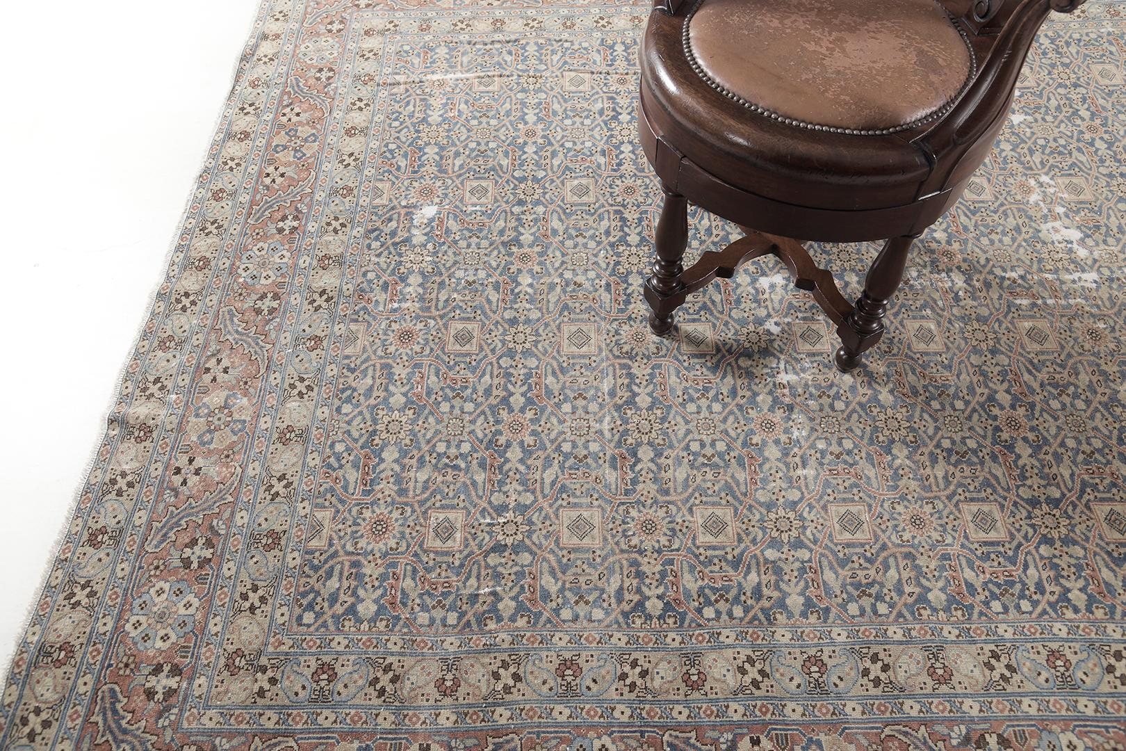 This timeless Tabriz Seneh Rug features a stunning pattern in a midnight blue field. From all the shades of a neutral tone, the scrolling vinery issuing split leaves is delicately woven around the rug and makes the borders well-complemented. A home
