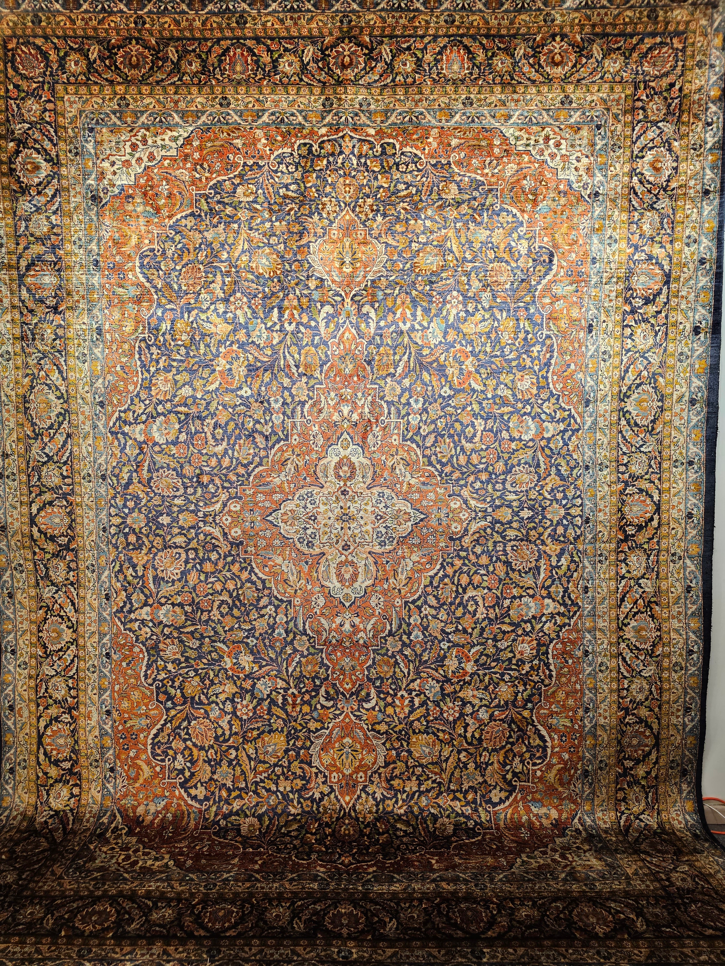 Vintage Persian silk Tabriz room size rug in a floral pattern with brilliant colors from the 3rd quarter of the 1900s.  The rug has a beautiful design and great silk color combination that shimmers under light.  It was hand woven at one of the city