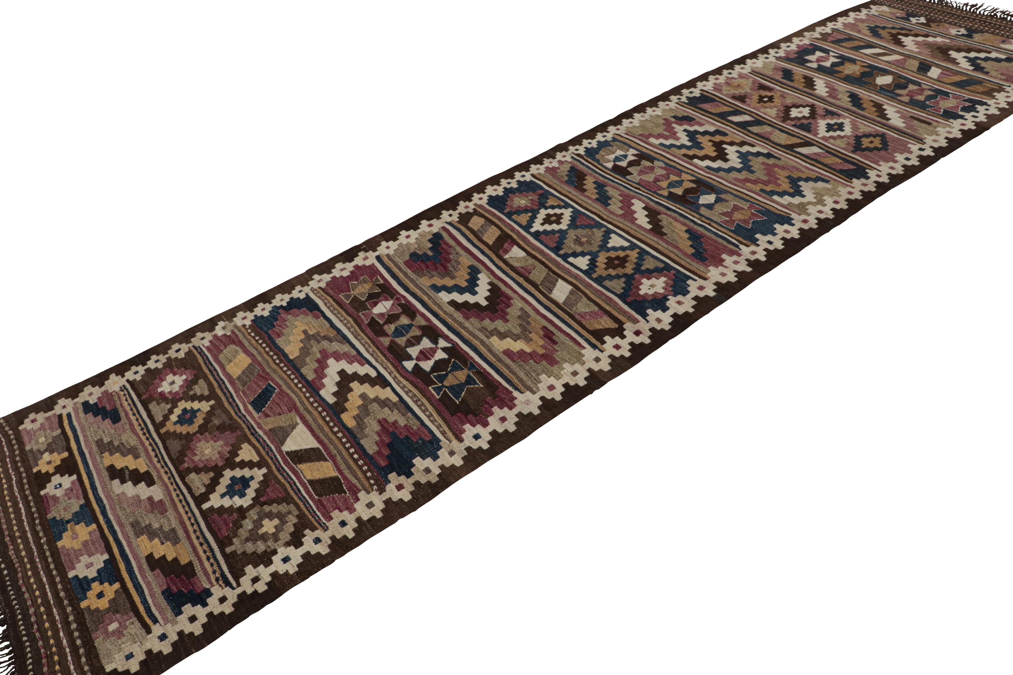 Hand-knotted in wool, this 3x14 vintage Persian tribal extra-long kilim runner rug has mosaic-like geometric patterns in beige/brown, red, blue, silver/gray, all over the field. 

On the Design: 

Connoisseurs will appreciate the vibrant blend of a