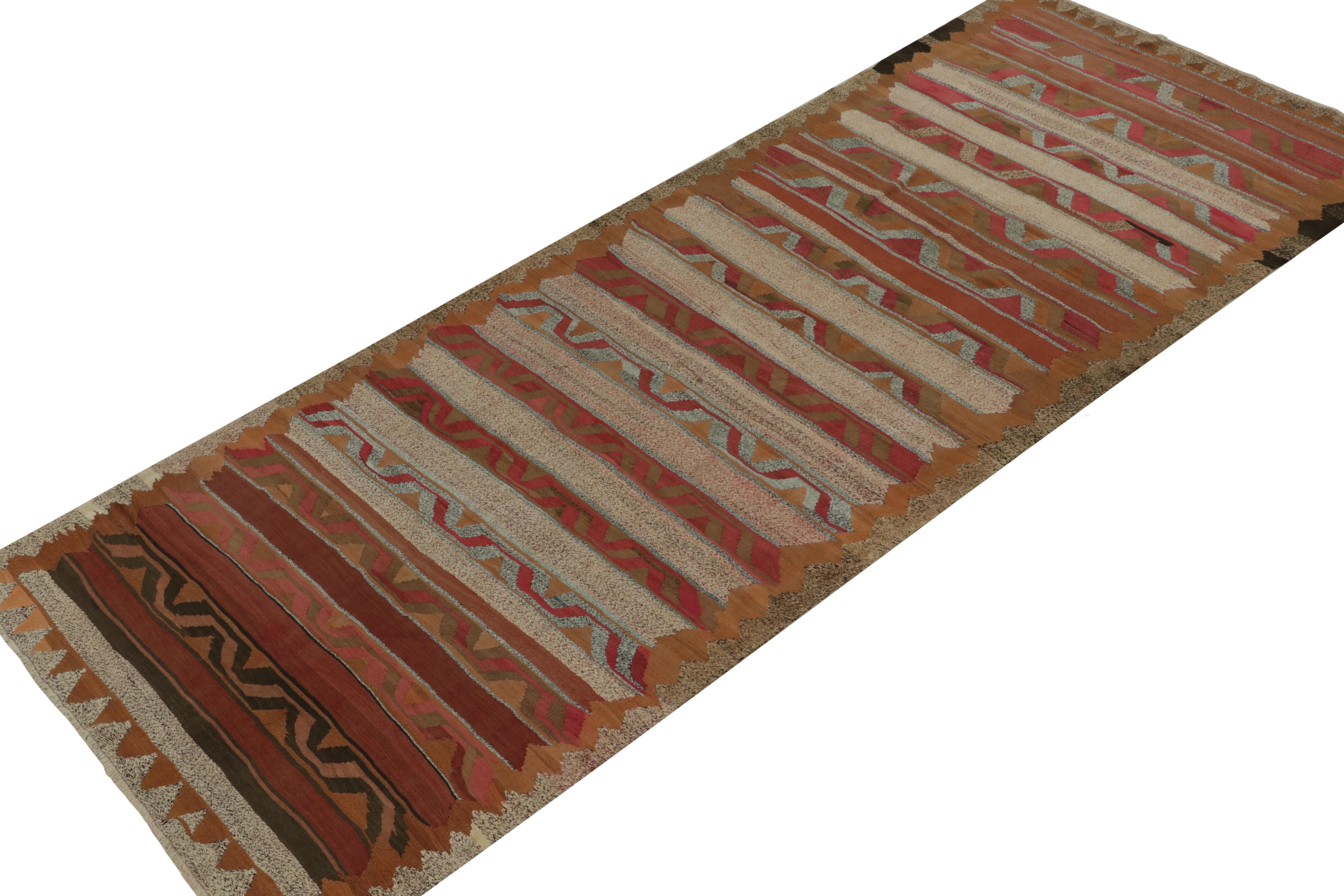 This vintage 5x12 Persian kilim rug is handwoven in wool, and believed to originate circa 1950-1960.

Further on the Design:

This traditional design prefers rich brown and red, but its highlights hint at a more unique tribal provenance. Light