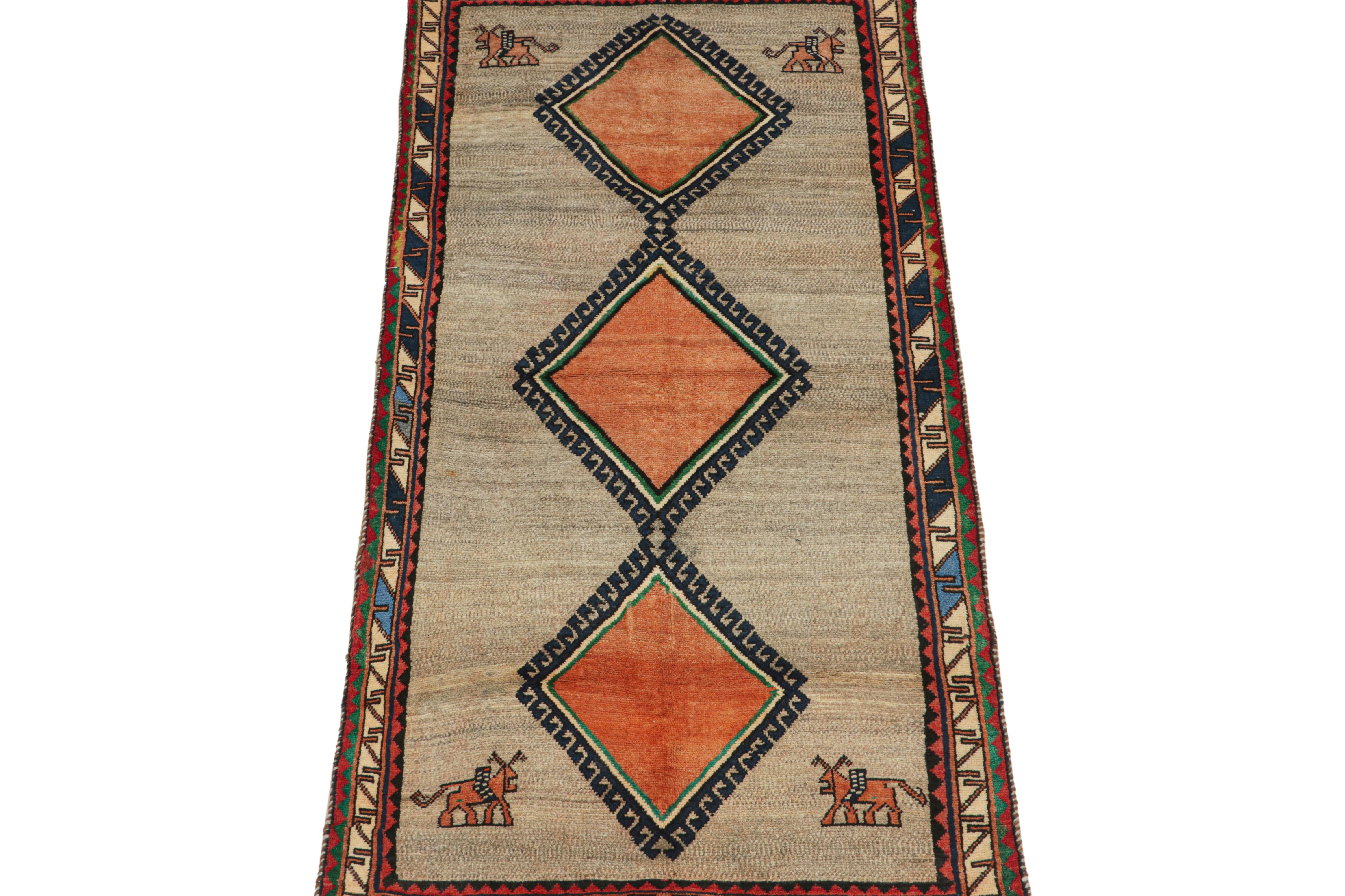 This vintage 3x7 Persian runner is a rare mid-century tribal piece, hand-knotted in wool circa 1950-1960.

Its design plays orange medallions on a beige and gray field within brightly colored borders with geometric patterns. Keen eyes will further