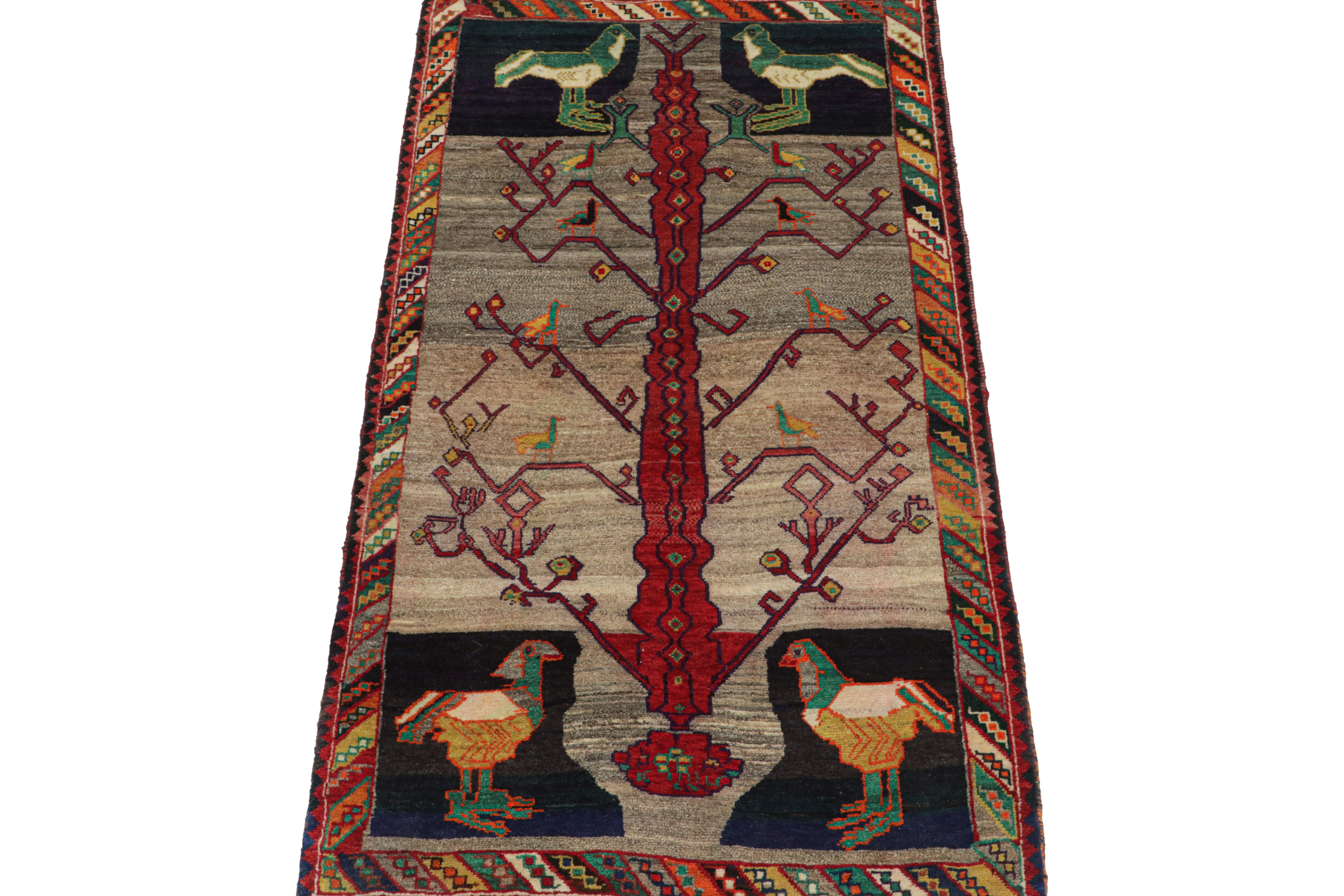 This vintage 3x7 Persian runner is a rare tribal rug, hand-knotted in wool circa 1950-1960.

Further on the design:

The design enjoys a colorful pictorial scene that depicts birds, large and small, on and beside the branches of a tree. It hosts