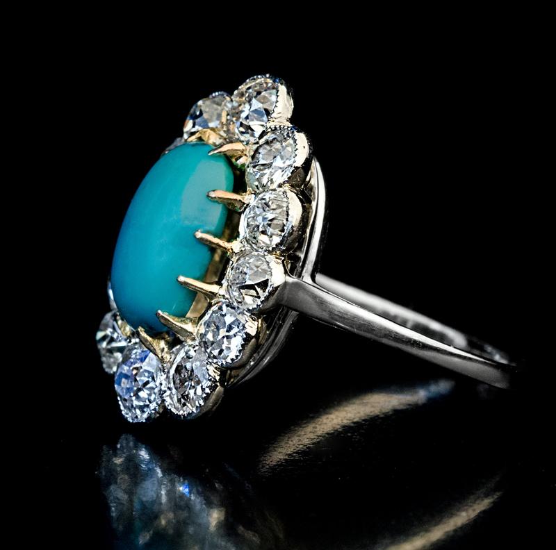 Circa 1920s

This Art Deco era platinum and gold (prongs) cluster ring features a Persian turquoise cabochon framed by bright white and very sparkly old European and old mine cut diamonds (F-G color, SI clarity).

The turquoise measures 10.52 x 7.54