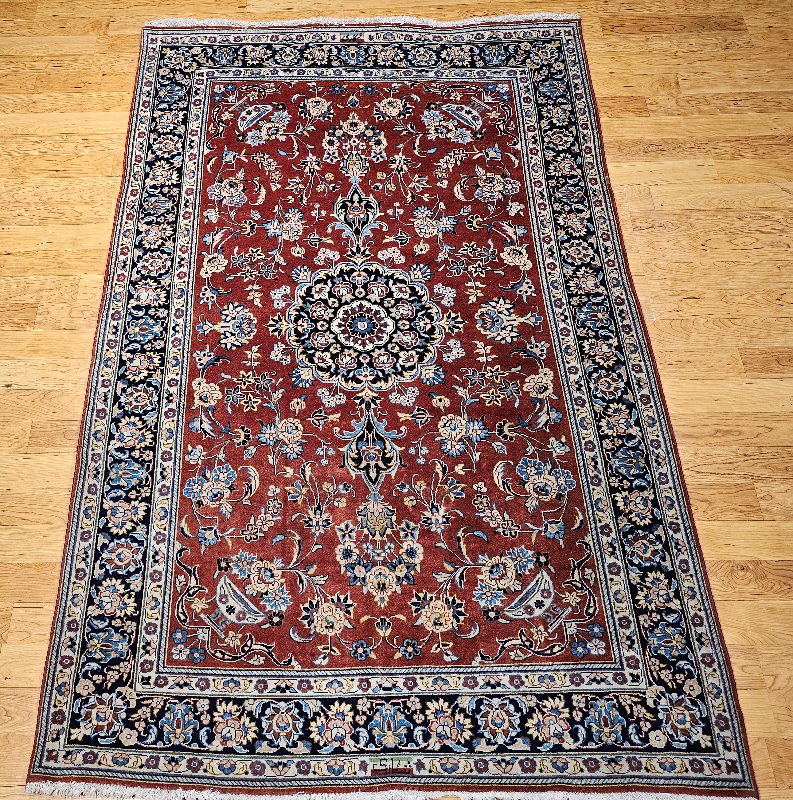 Vintage  Persian Yazd rug in a floral pattern in Brick Red, Navy, Blue, Ivory from the mid 1900s.   The was was woven at the  