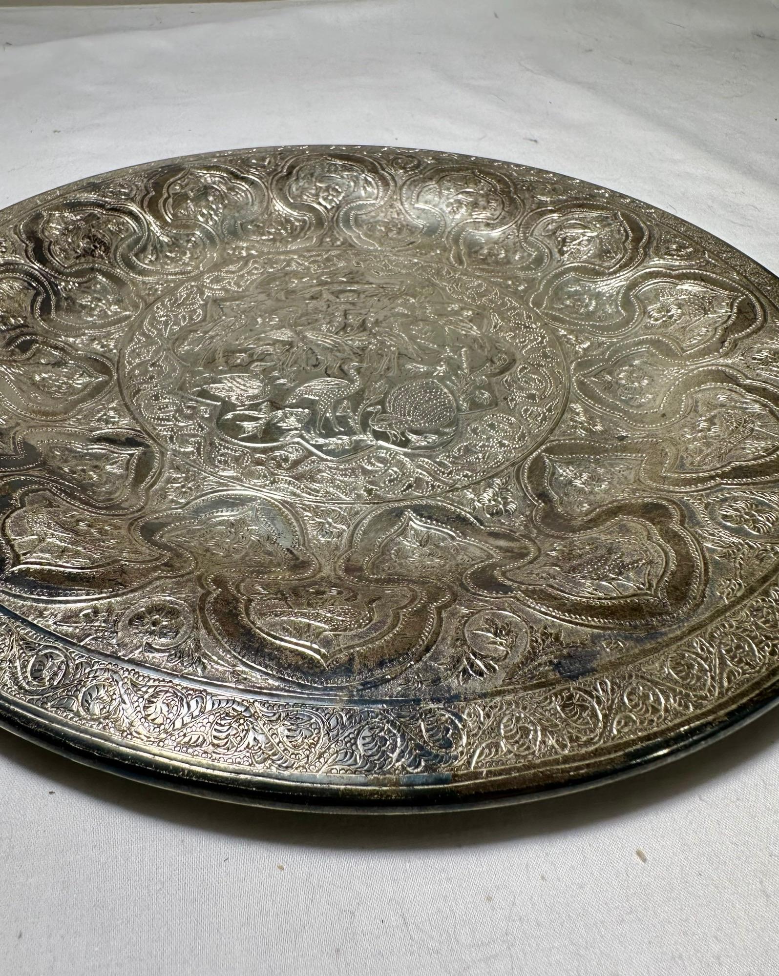 Vintage Persian Zandi Middle Eastern Islamic Round Silver-Plated Brass Platter.
 
Ce plateau en laiton lourd, plaqué argent et fabriqué à la main, est gravé, gaufré et poinçonné de motifs mauresques centrés sur de nombreux oiseaux décoratifs