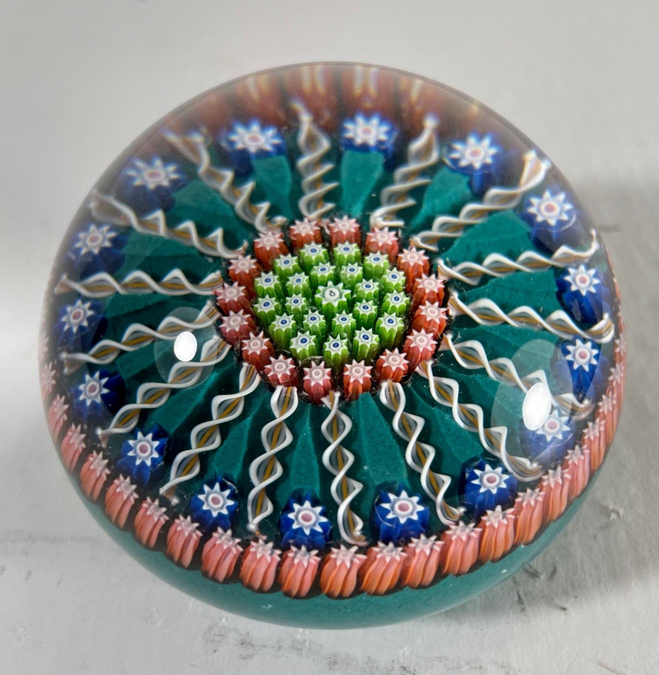 Vintage Perthshire Millefiori art glass paperweight

This vintage millefiori and twist art glass paperweight was handcrafted in Crieff, Scotland at Perthshire Paperweights, Ltd. It is designed in a pattern of colorful millefiori canes separated by
