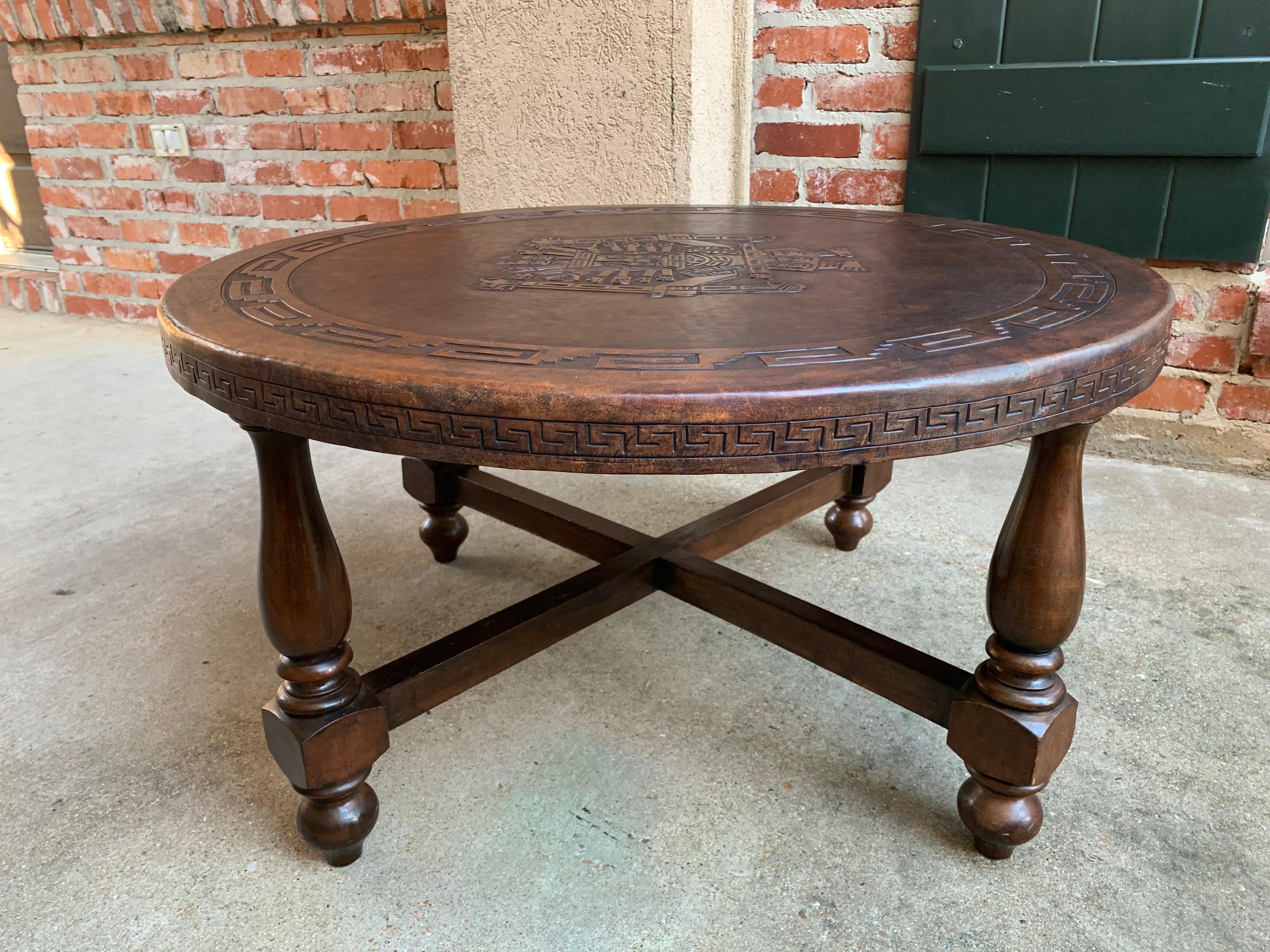 Direct from England, ~Included in our latest container from the antique fairs near London, England, is this gorgeous embossed leather round coffee table!~
~Burgundy/brown tone leather has large embossed Aztec tribal warrior center with wide Greek