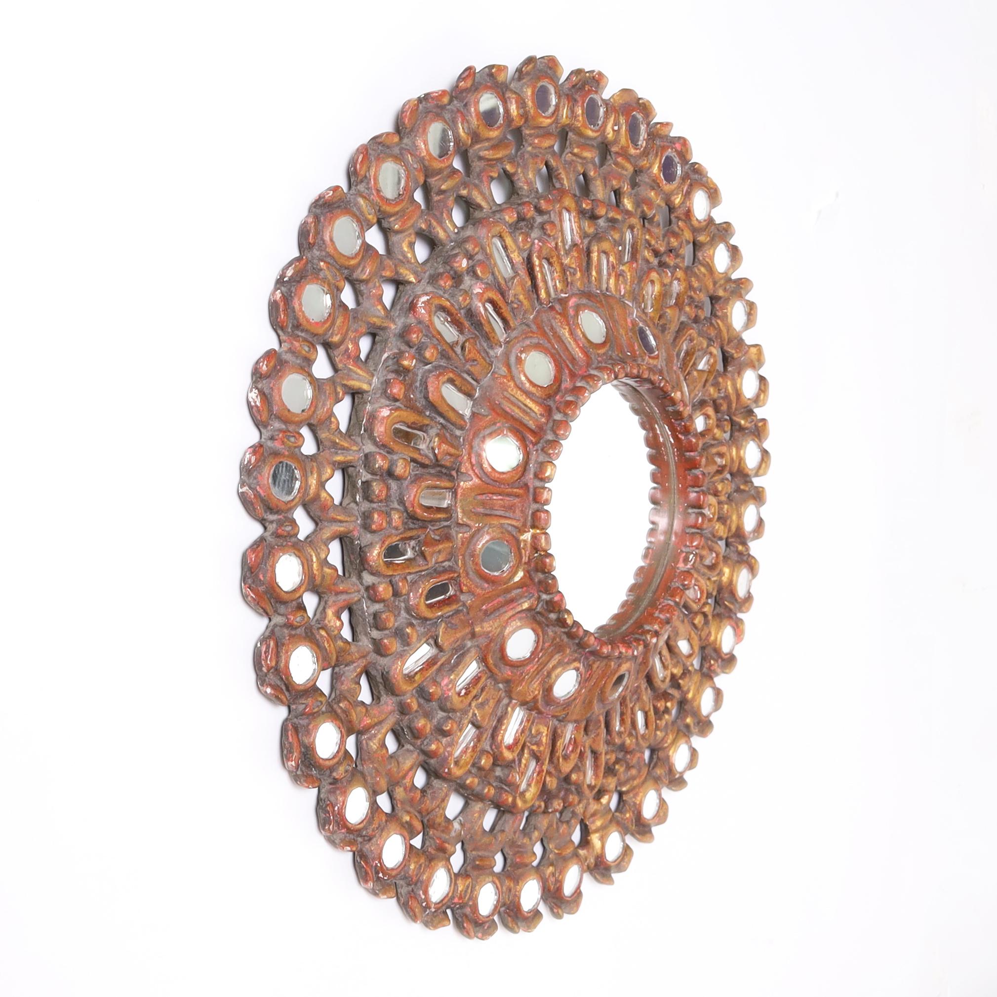 Mid century Peruvian wall mirror ambitiously carved with open fretwork, gessoed, primed and gilt, featuring seventy-seven strategically placed mini mirrors around the frame.