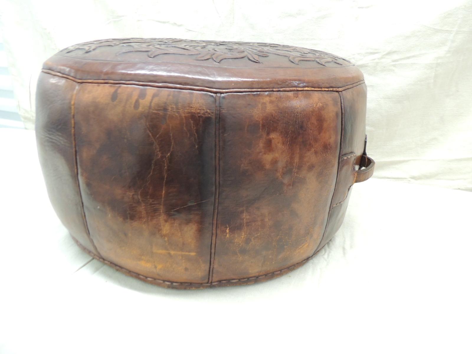 Vintage Peruvian leather ottoman with handles
Round cognac color leather ottoman with embossed vine patterns on the top of the piece. Woven underside leather closure. Hand stitched leather patterns all around
Size: 22