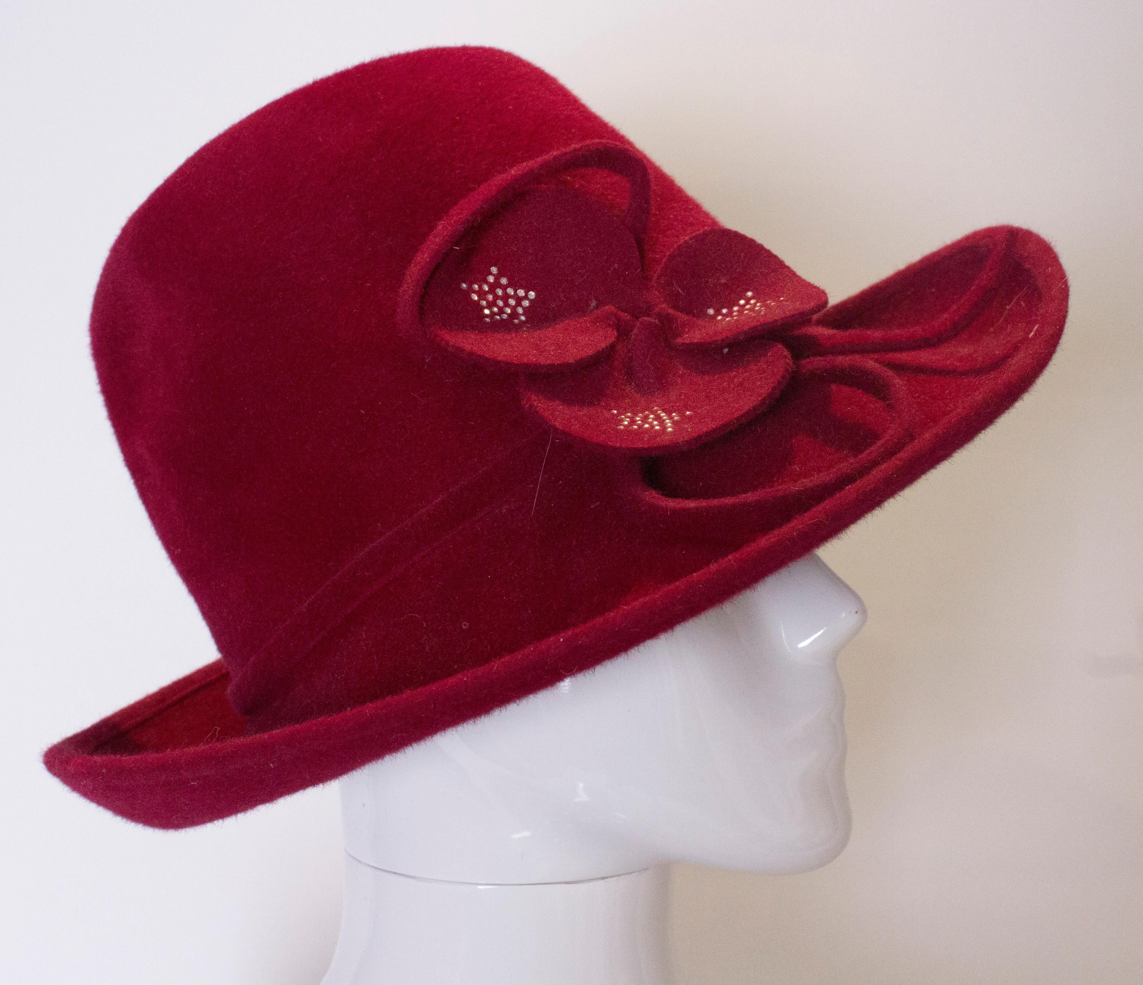 A great hat for fall/winter by Peter Bettley. In a plum colour the hat has an attractive floral detail with diamante on the petals.