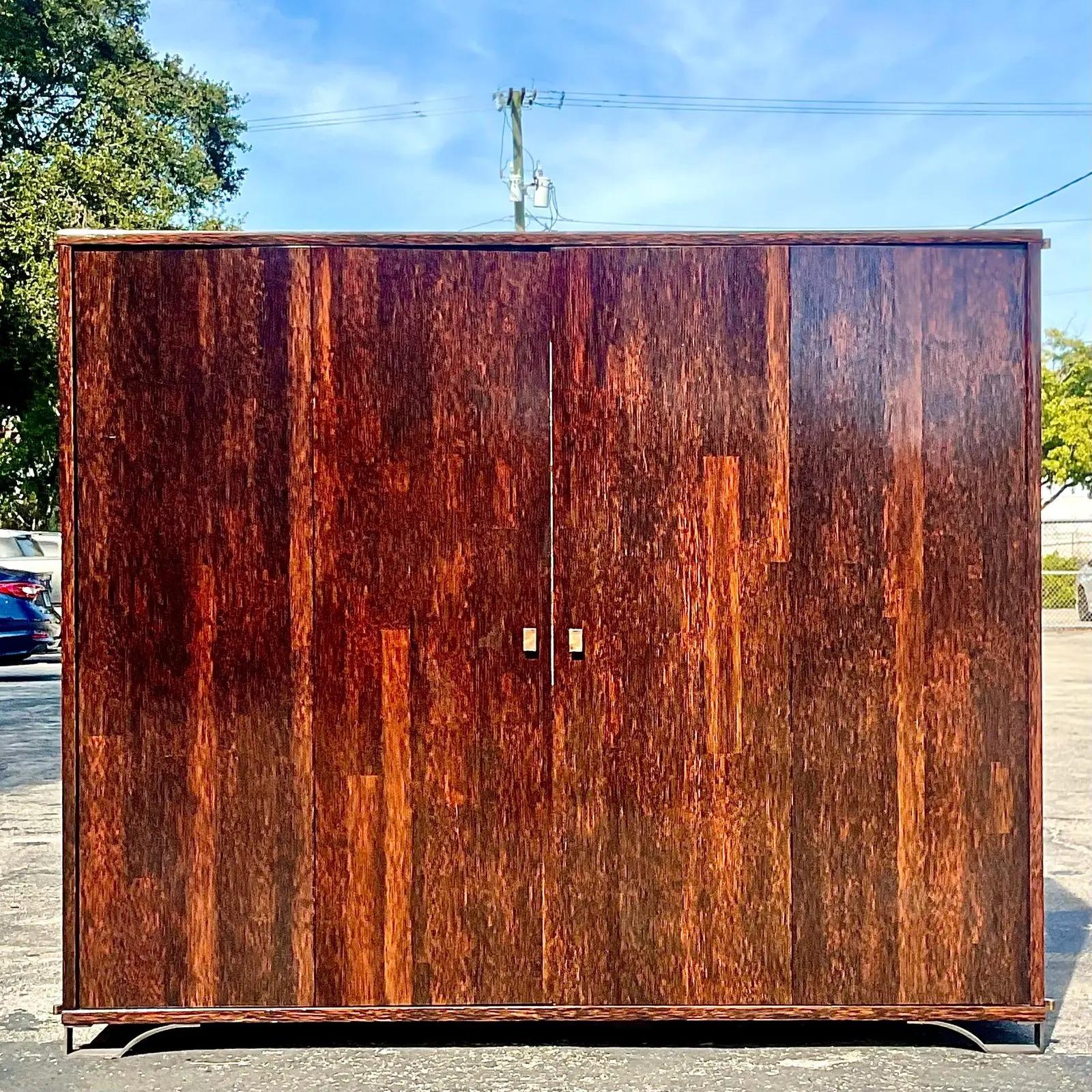 An exceptional vintage contemporary wall cabinet. Made by the legendary Peter Marino for a private Palm Beach client. Chic Rosewood cabinet with custom bronze hardware. Interior light ash shelving currently outfitted for a TV. Soft touch drawers and