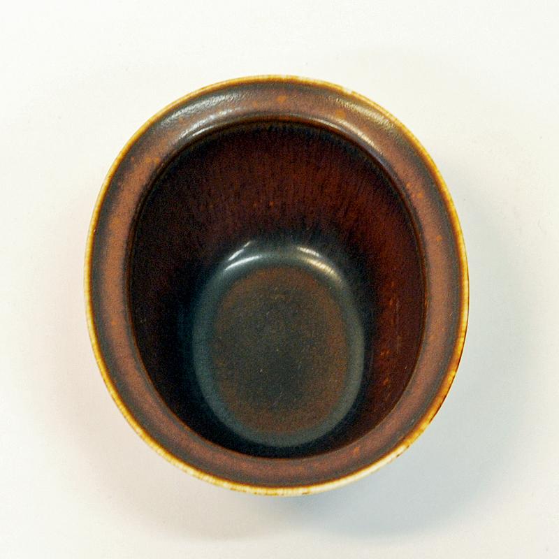 Practical midcentury stoneware bowl by Gunnar Nylund for Rörstrand, Sweden, 1950s. Perfects size for nuts, sugar, sauces, spices etc. or just for decoration. Lovely rustic brown color.
Measures: H: 13.5cm L x 11 cm H x 6 cm D.
Glazed bronze