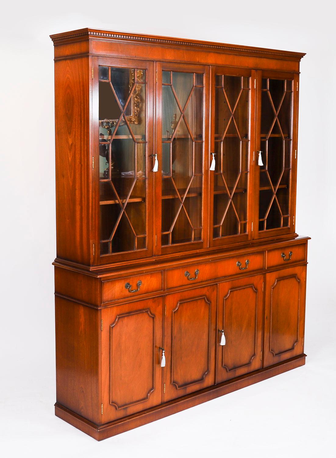 Encantadora librería vintage de caoba flameada de estilo renacimiento georgiano, de mediados del siglo XX.

La parte superior presenta una cornisa moldurada decorativa con un friso dental y porticado.

Las cuatro puertas acristaladas en forma de