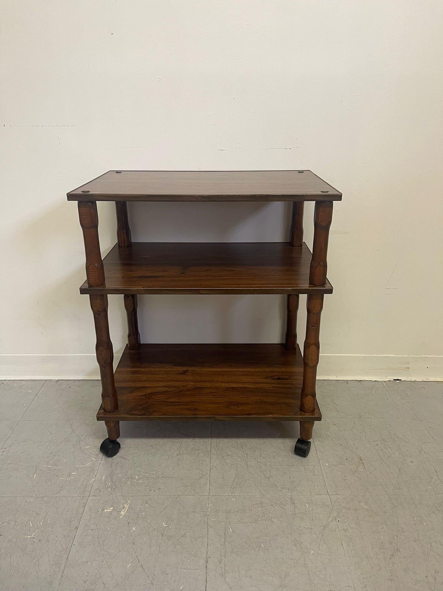 This Bookshelf has three levels connected by turned wood legs. On casters. Vintage Condition Consistent with Age as Pictured.

Dimensions. 24 W ; 16 D ; 29 H