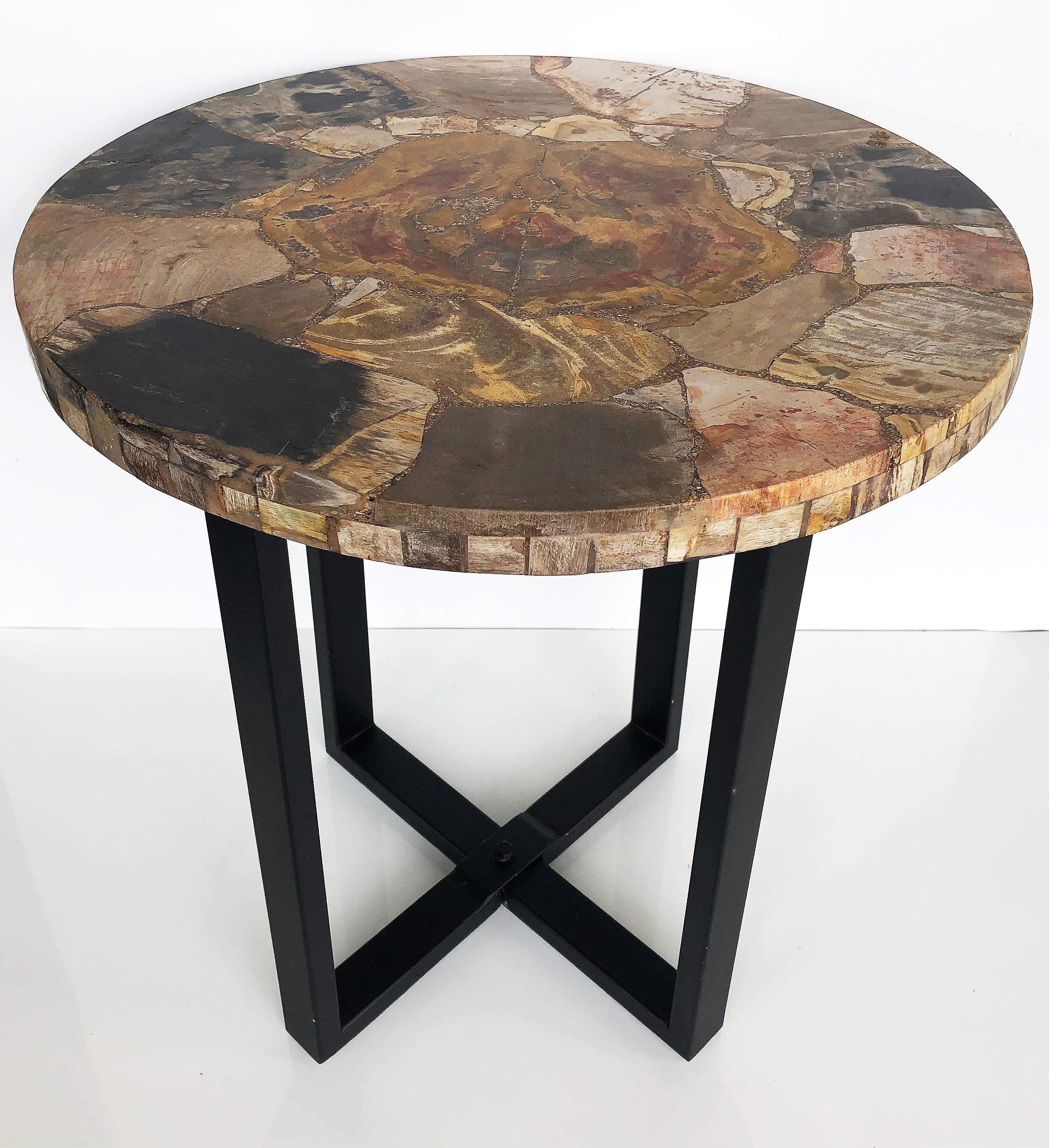 Vintage petrified wood side table on a metal base

Offered is a round petrified wood side table with tesselated edging supported by a cross stretcher metal base. The top is made in Thailand incorporating petrified wood and other specimens as