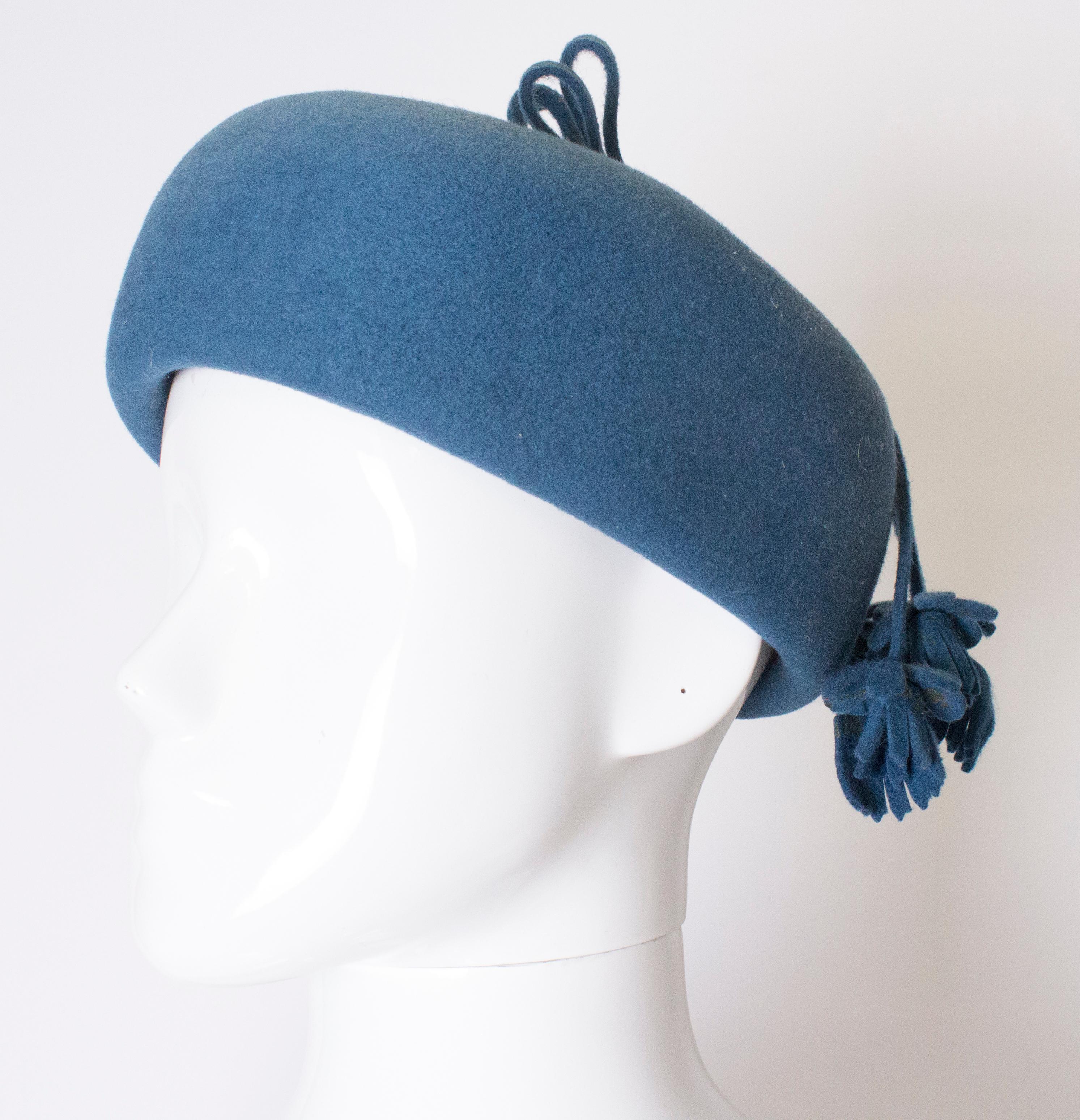 A chic hat for Fall , in a stunning petrol blue colour.  The hat is an oval pill box shape, and measures 3'' in height, and has a inner circumference of 22''.