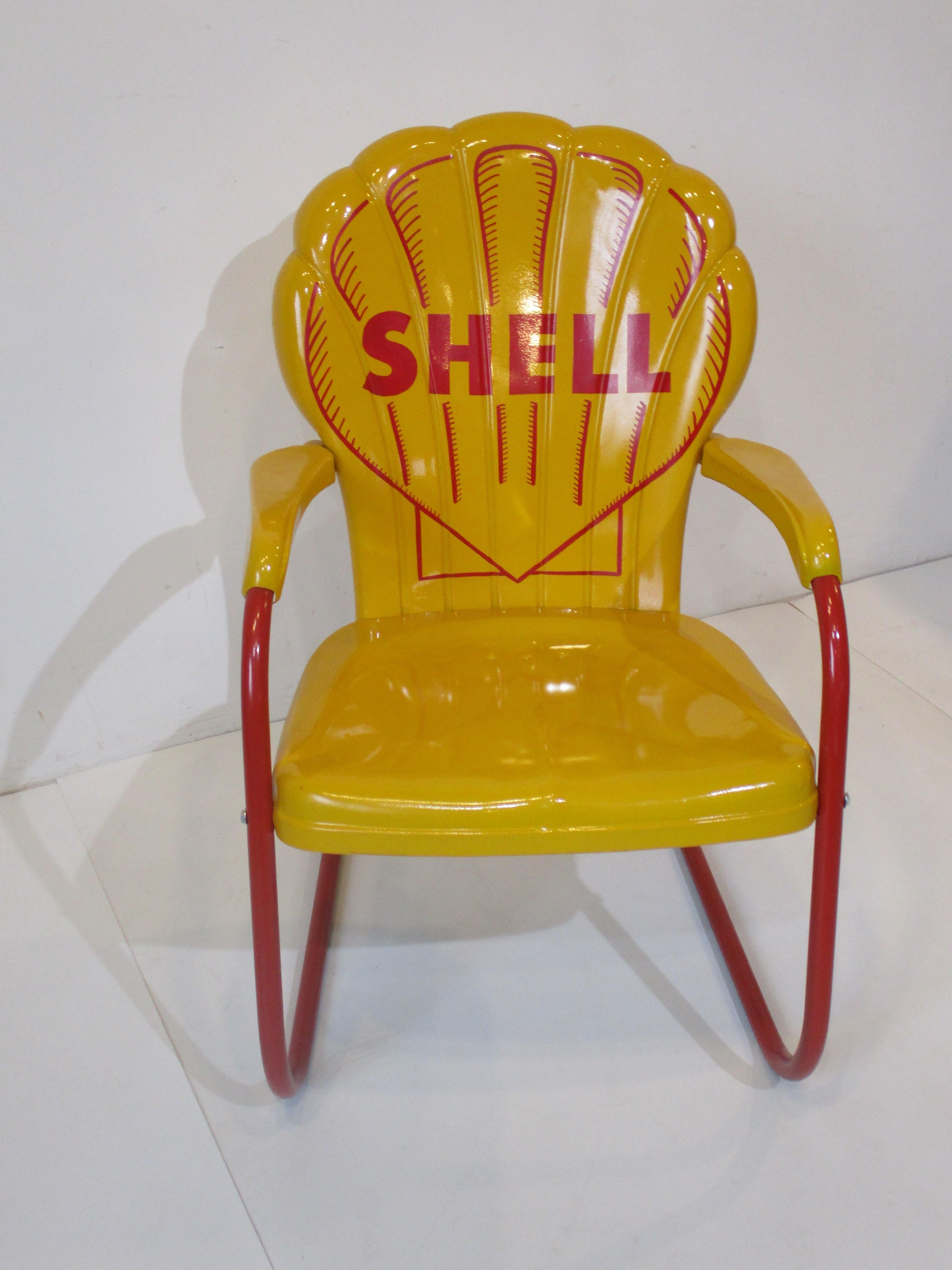 A petroliana vintage Mid Century pressed metal arm chair with hand painted Shell oil company logo . The script is on the front back rest of the chair with scalloped top edge in the style of a shell done in the companies yellow and red colors . The
