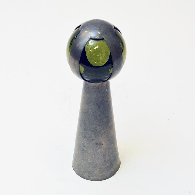 A rare and classic Norwegian pewter hand bell with a transparent green glass ball handle on the top surrounded by pewter strings. Made by Gunnar Havstad (b.1901 - d. 1973) from his own pewter workshop/studio in Nesodden - Norway 1950s. Special