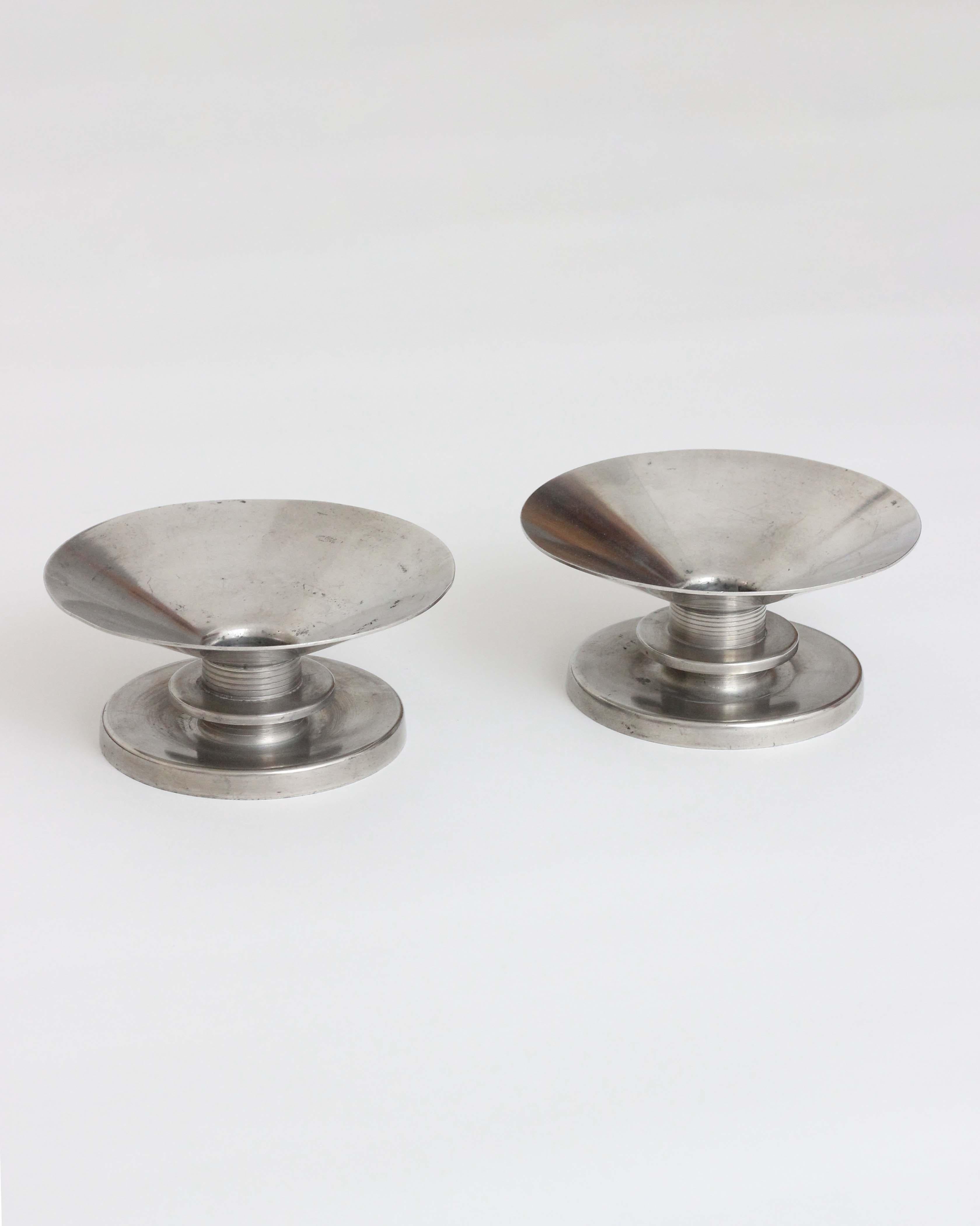 Sylvia Stave 

Candlesticks in pewter showcasing a round foot adorned with stylish stripes and an intricately tied knot. Its cuffs gracefully expand in an upward direction, resembling a cone-like shape.

From 1931 to 1939, Sylvia Stave held the