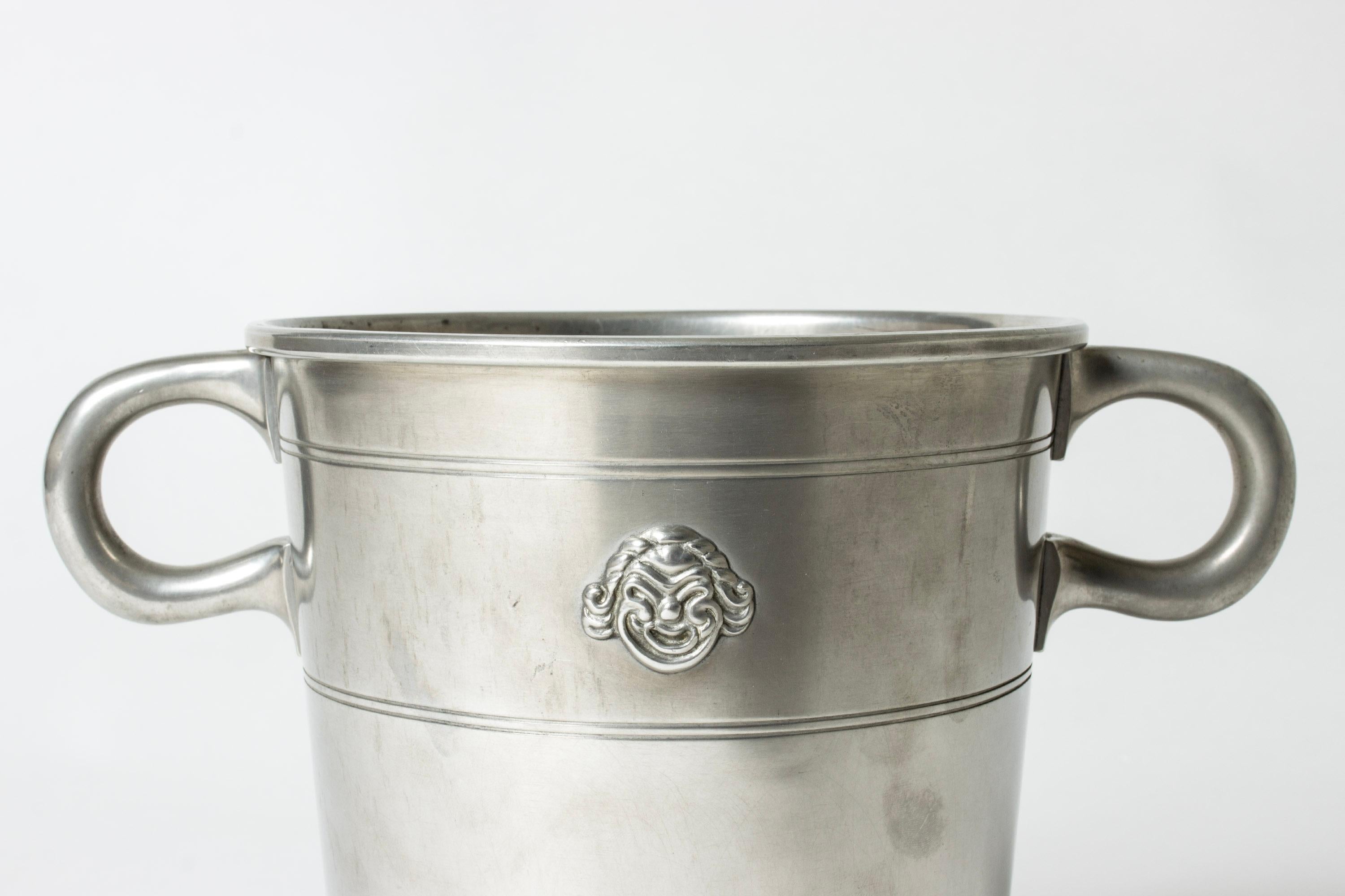 Elegant pewter ice bucket by Hugo Ghelin. Clean form with humorous gleeful and flustered faces.