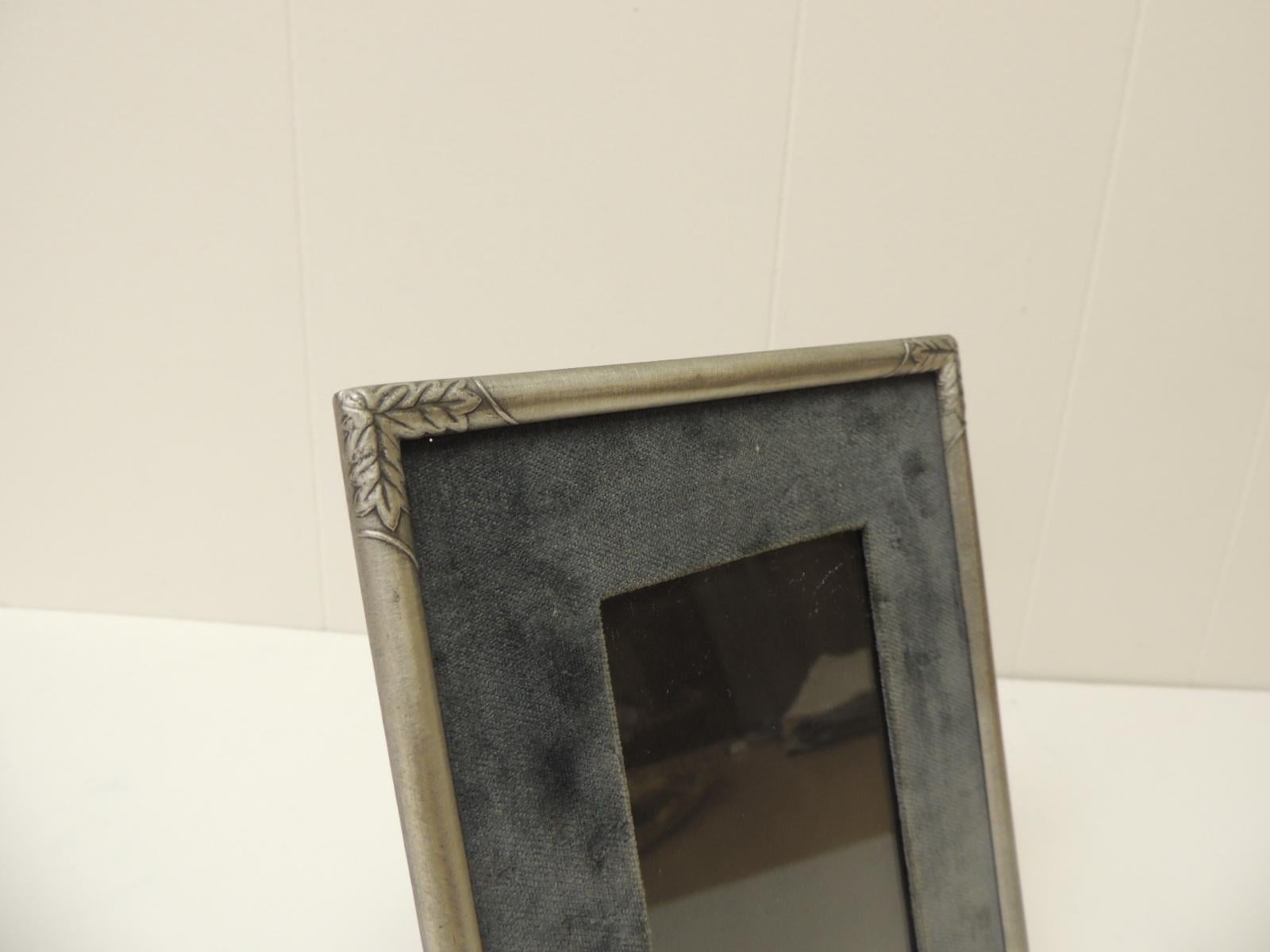 Vintage Pewter Picture Frame with velvet inset panel and glass under.
The corners of the frame have small leaves design.
The inset velvet is grey in color.
Inside image/Picture size: 3 1/4