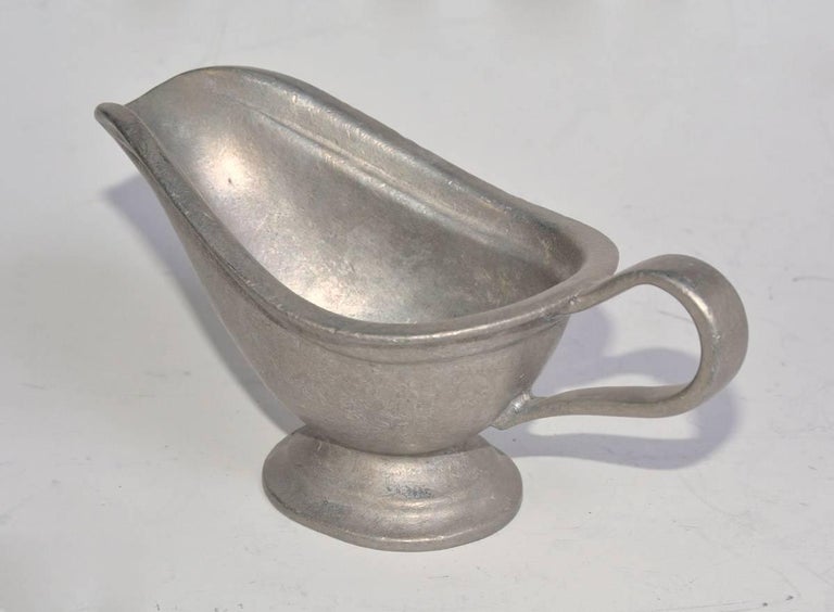 The vintage pewter boat is used for serving sauces or dressings.