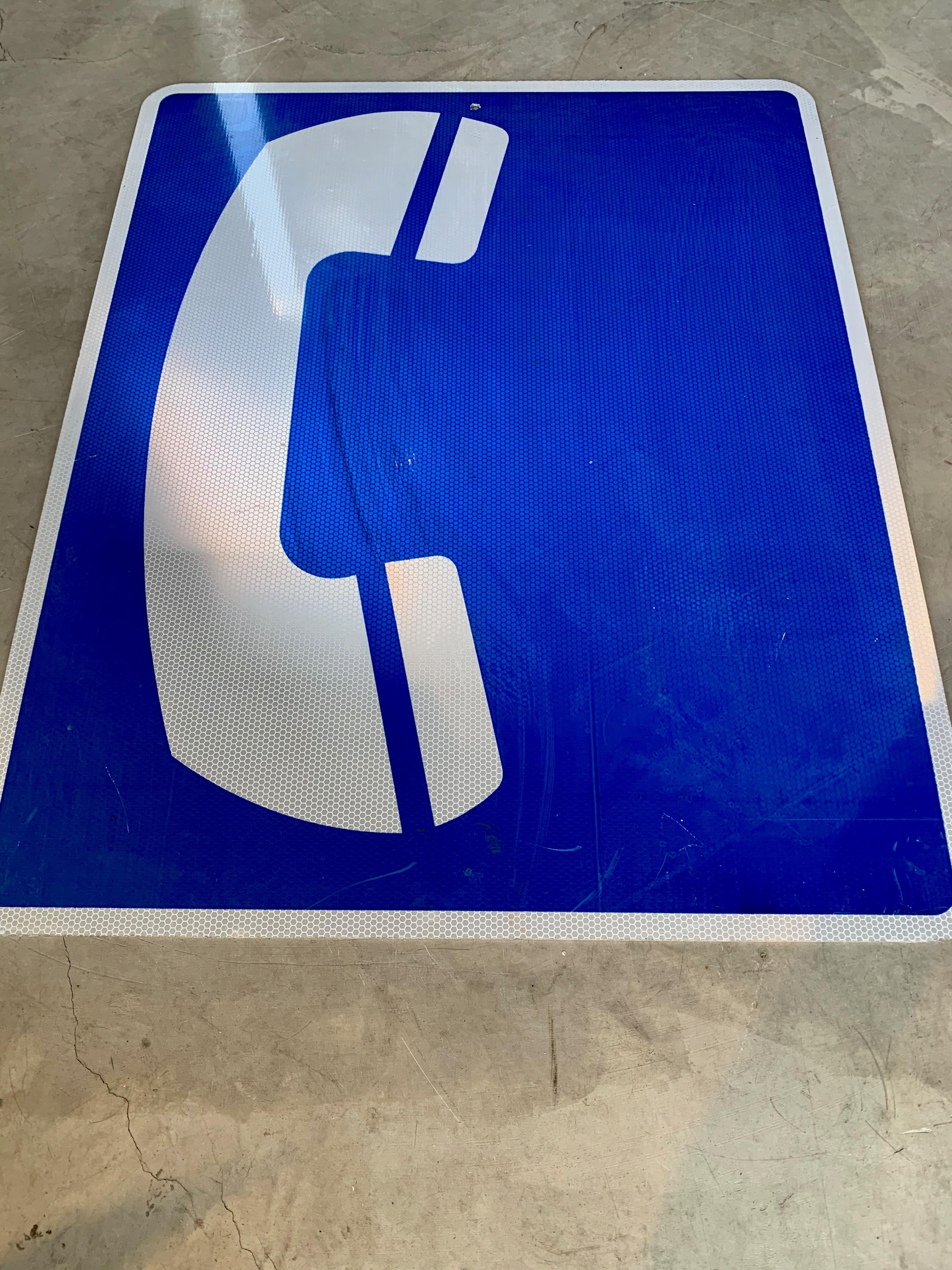 Cool vintage highway sign in cobalt blue reflective metal. Depicts a large white phone on a blue background. Sign was used to direct drivers to a callbox or phone up ahead. Large size at 24