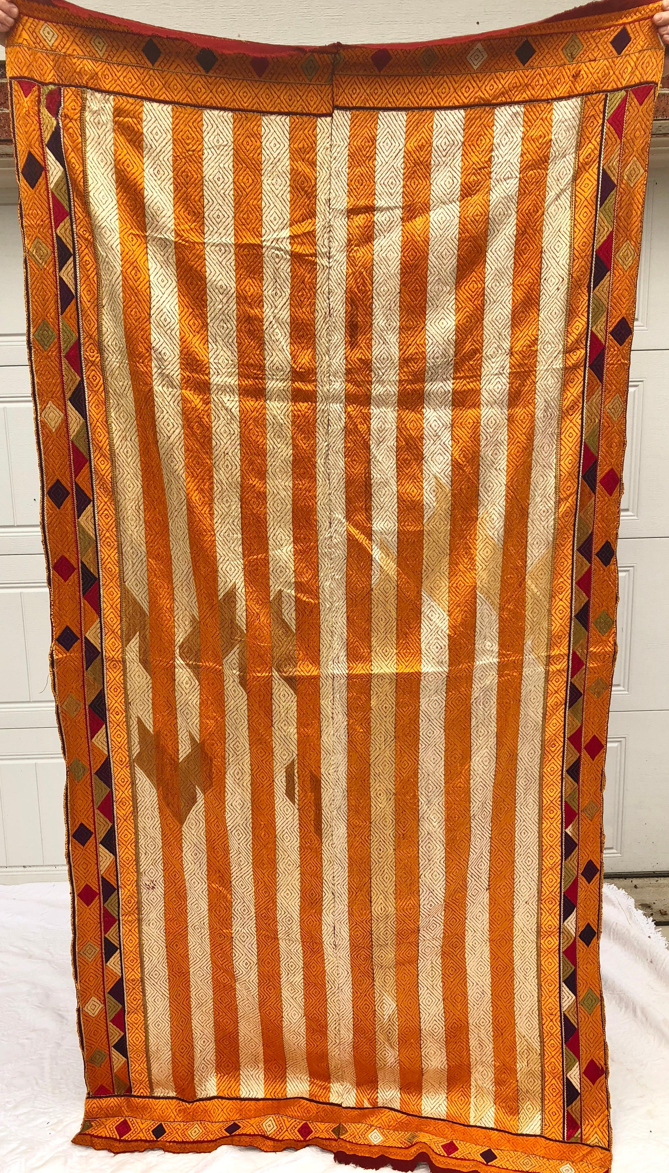 Vintage phulkari bagh wedding shawl from Punjab, India. The cotton hand loomed khadi cloth is hand embroidered with vibrant silk threads by members of the young girl's family for her wedding. Shawl is in good condition for it's age. There are no