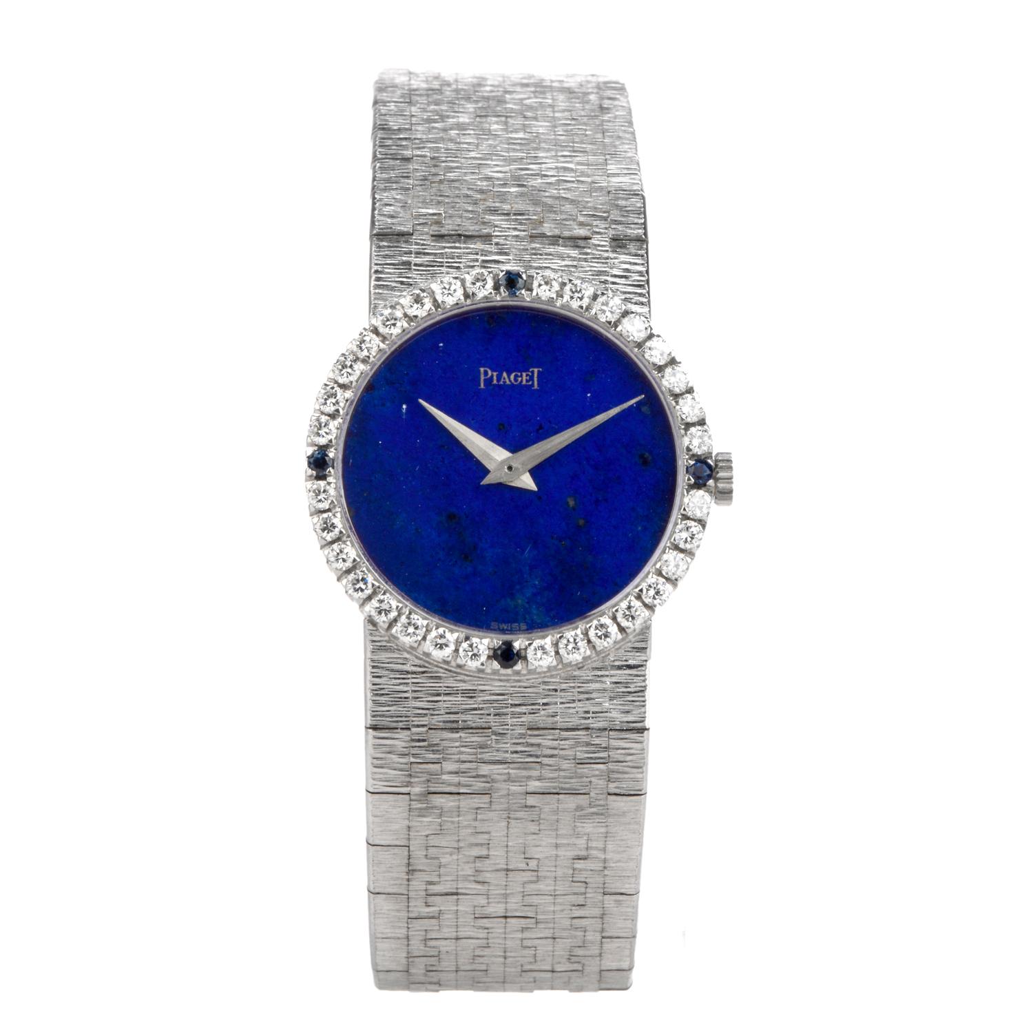 Circa Late 1960’s designer Piaget ladies watch crafted in solid 18-karat white gold. Embellished with a 32 diamond and 4 blue sapphire crown. Sapphire Crystal ,lapis Dial, 24mm case with 32 factory set round diamonds approx. 0.75 carats, E-F color