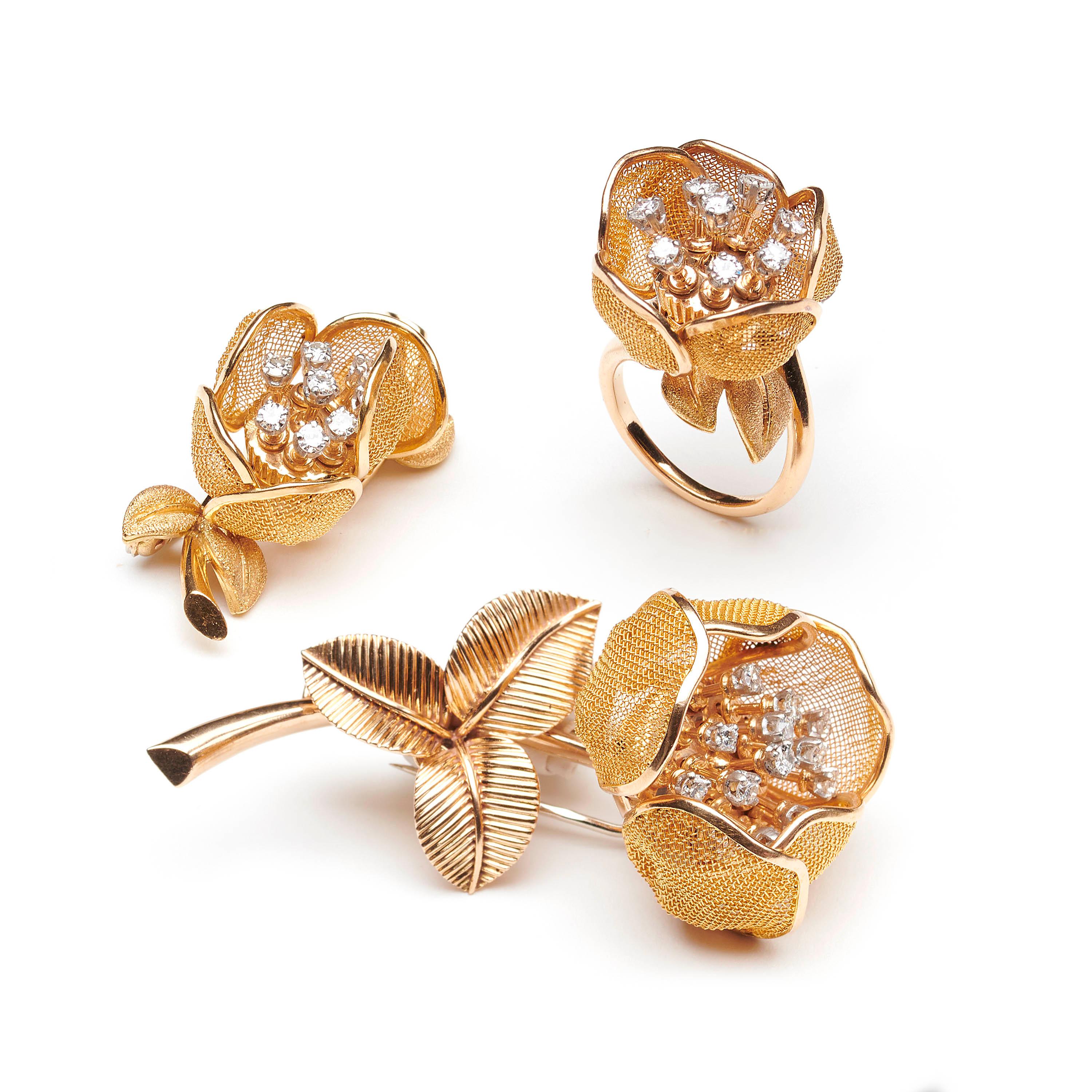 A vintage Piaget diamond and gold flower suite, comprising a ring, designed with articulated gold mesh opening and closing petals, diamond set stamens and textured finished leaves, together with two diamond set flower brooches, both with gold mesh