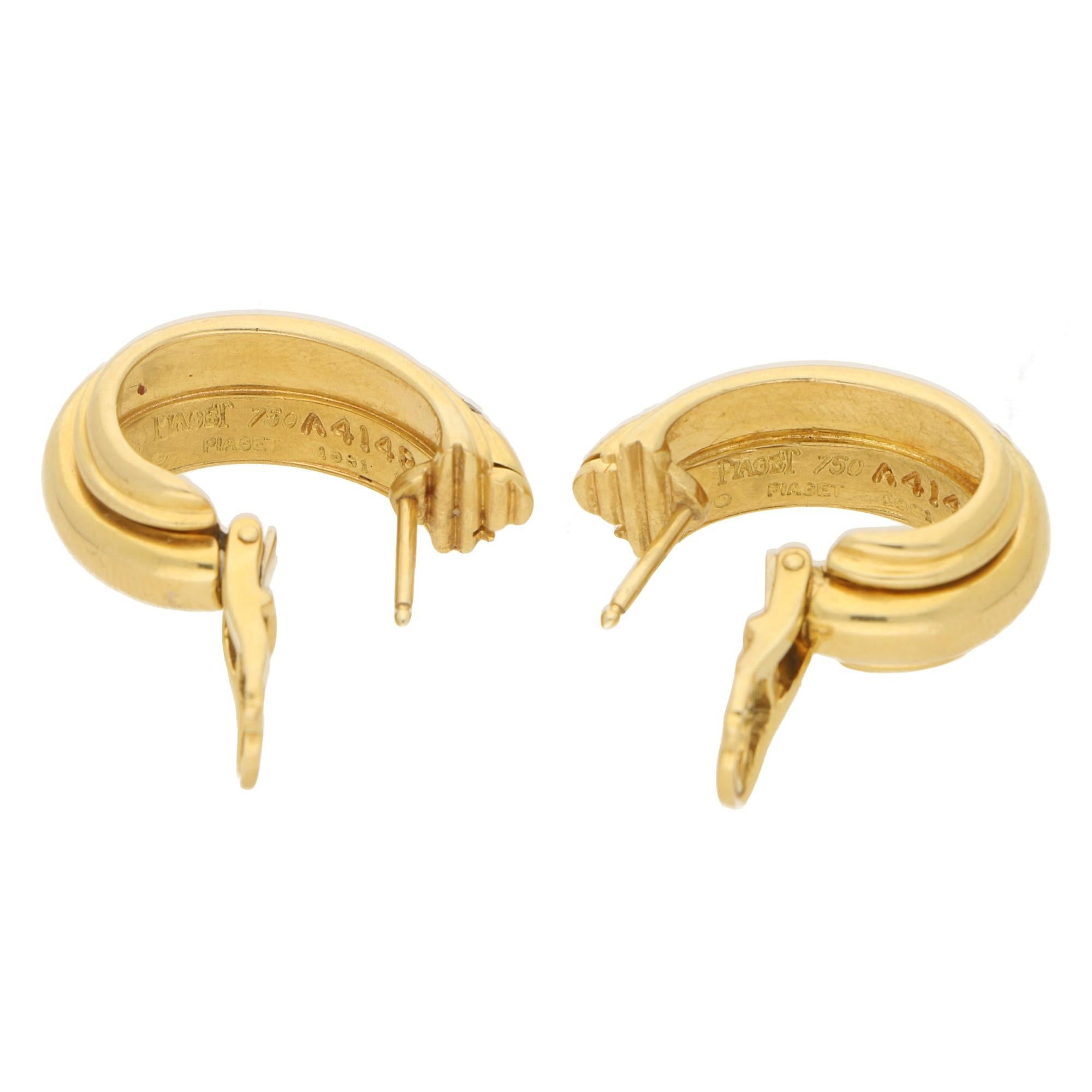 A beautiful pair of Piaget Possession diamond hoop earrings set in 18k yellow gold. Each earring is set with 3 round brilliant cut diamonds in rubover settings, featuring the signature floating hoop to the centre. The pair give off an etruscan style