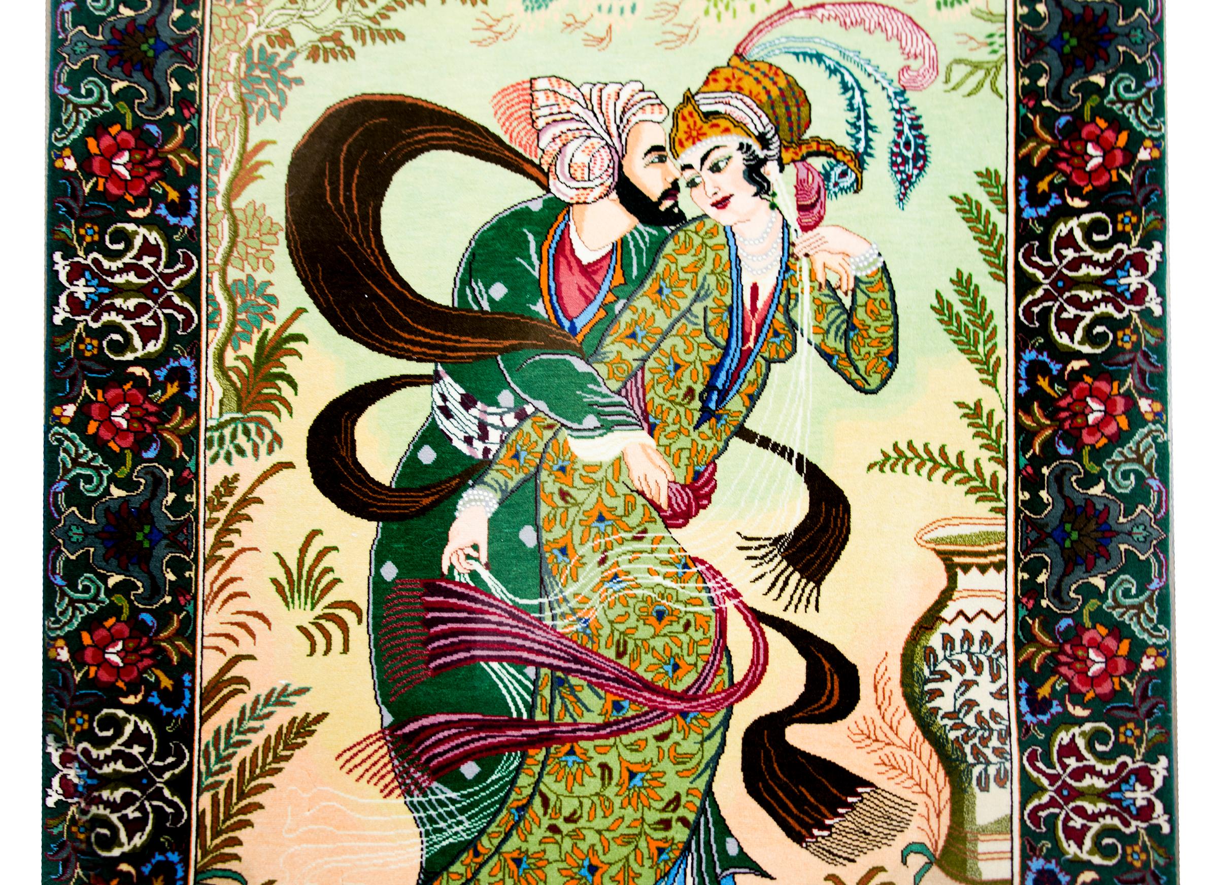 A vintage Persian Tabriz pictorial rug depicting a couple embracing with feathers, scarves, and ferns swirling around them, and surrounded by a wide floral and leaf patterned border.