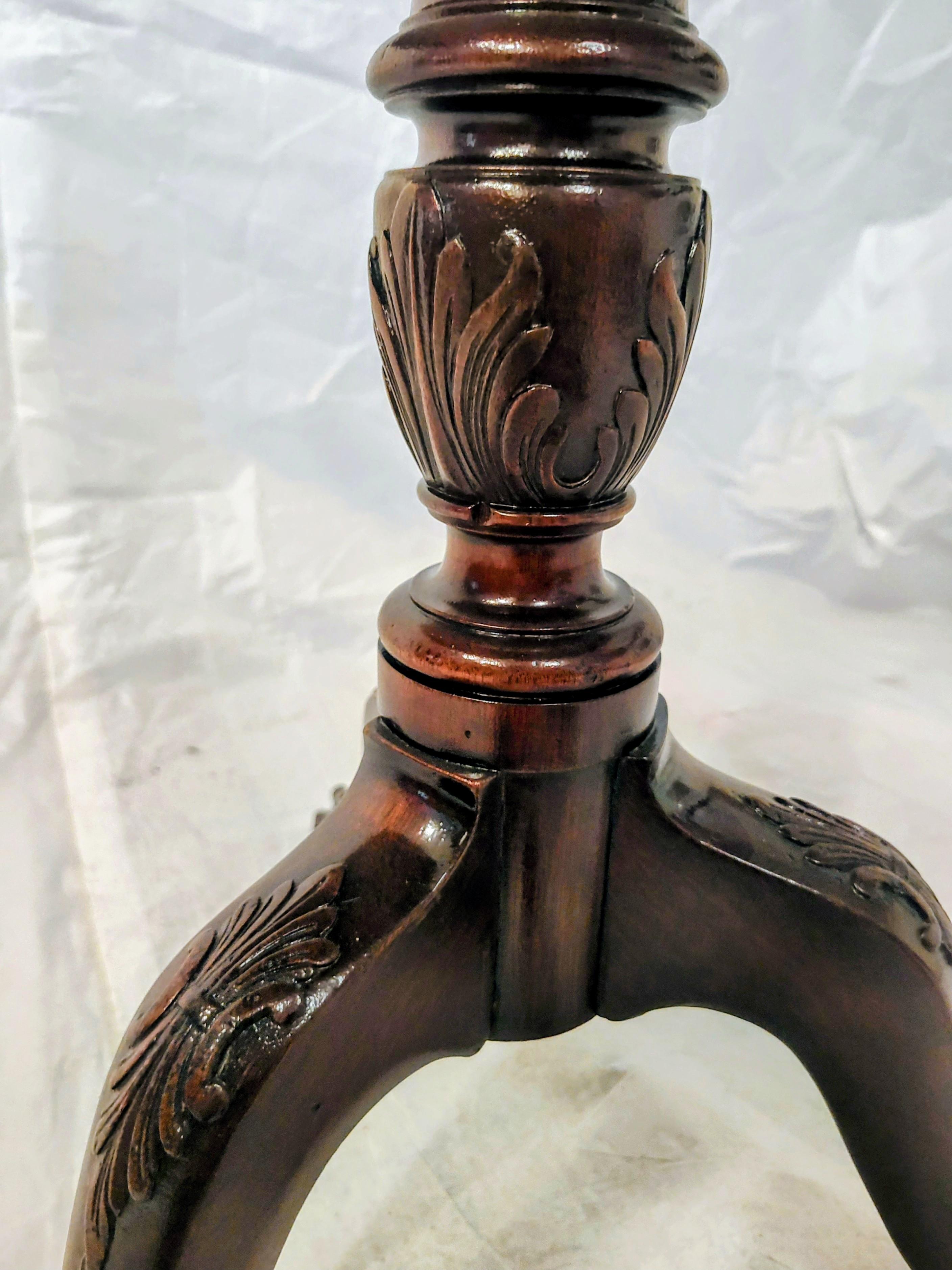 Tavolo da tè inclinabile in crosta di mogano vintage. Questo  bella  Il tavolo antico ha un piano in mogano massiccio figurato/scanalato, foglie d'acanto ben intagliate sulla parte dell'urna del fusto e sui piani delle gambe e un bordo in crosta