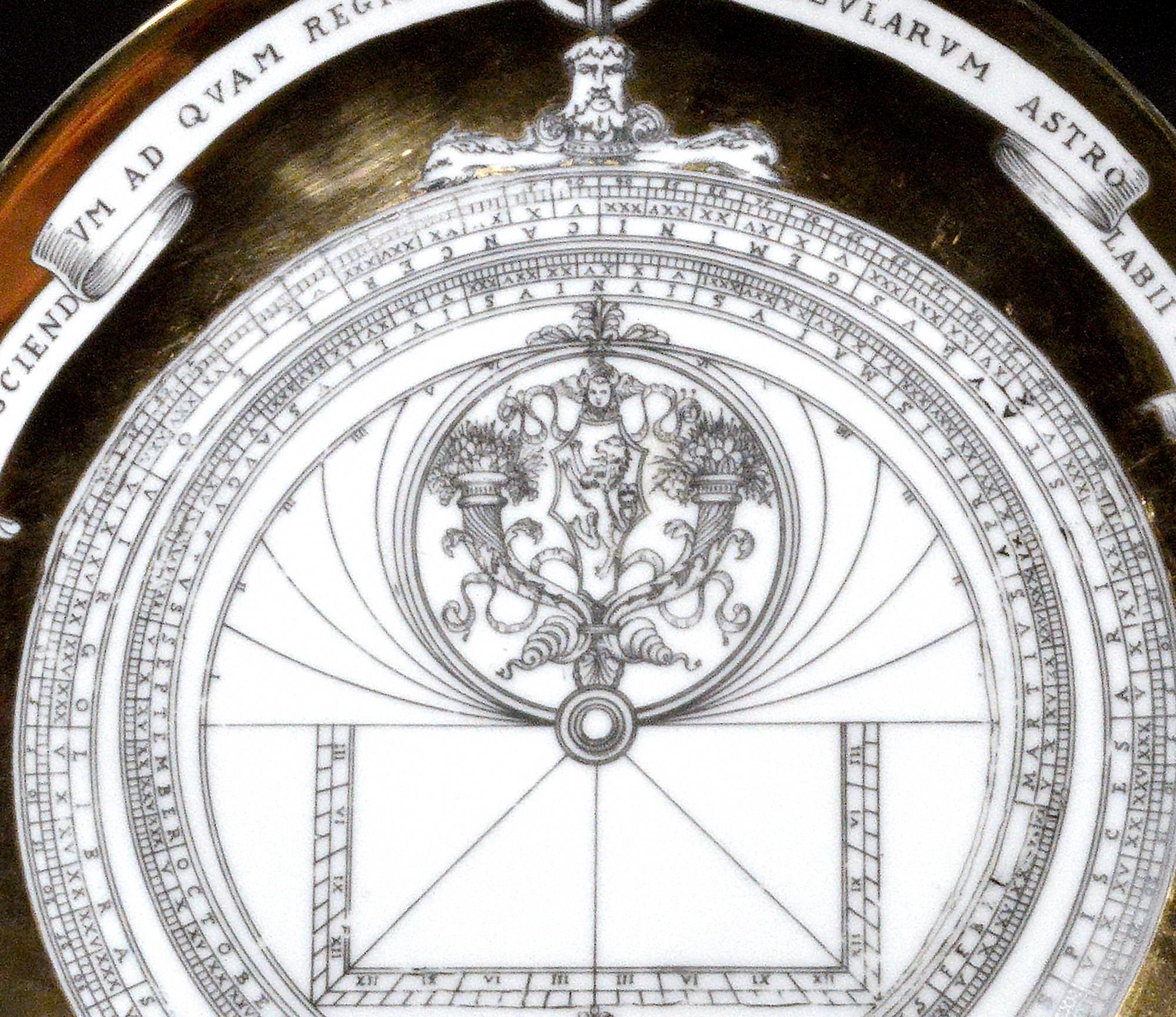 Vintage Piero Fornasetti Assiette astrolabe en porcelaine,
#11 dans Astrolabio Pattern.
Années 1960-milieu des années 1970.

La plaque représente un astrolabe, c'est le numéro 11 de la série. Un ruban au-dessus indique Ad Sciend Vm Ad Qvam