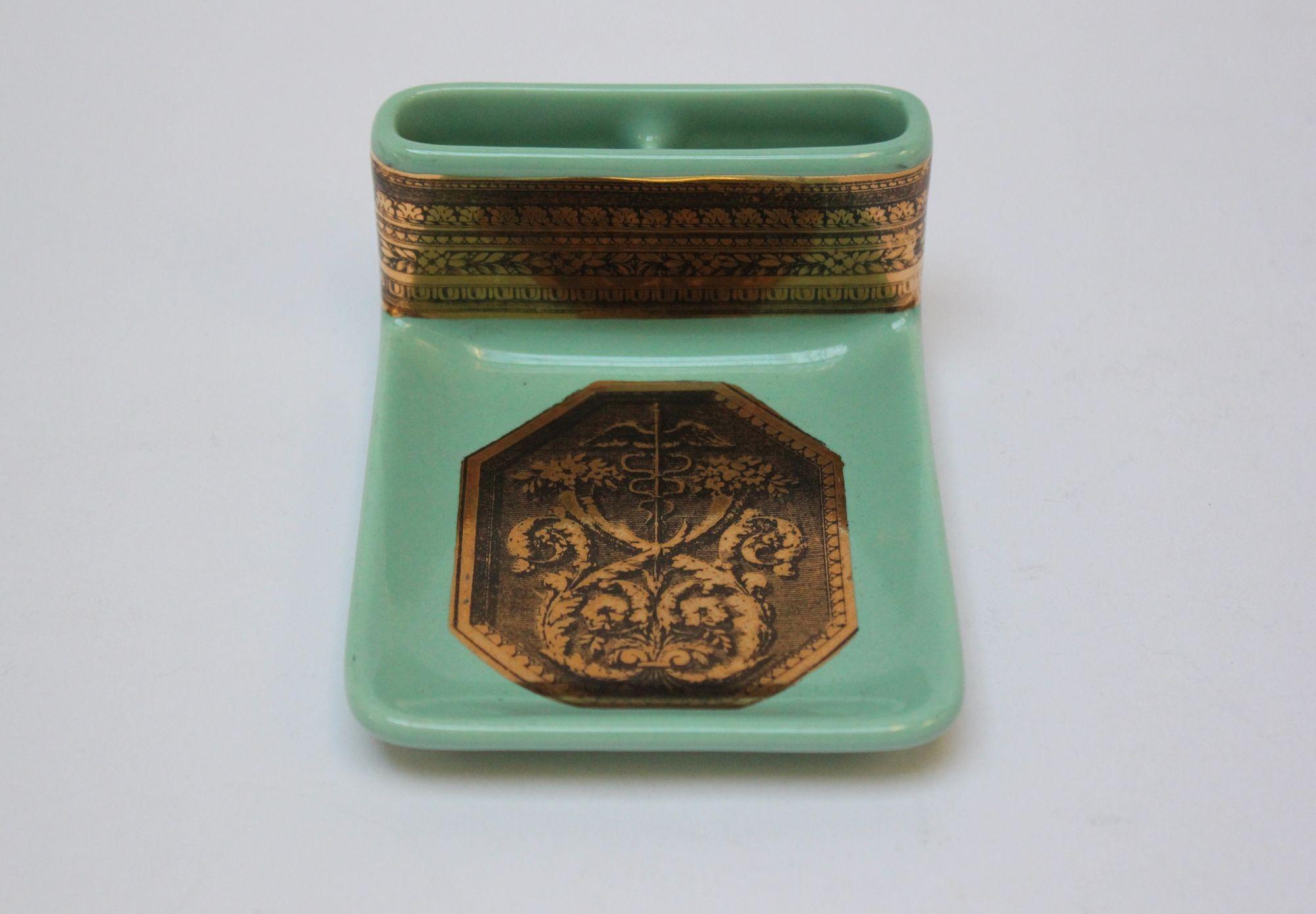Vintage celadon/mint green ceramic ashtray/trinket dish with cigarette slots by Piero Fornasetti, (circa 1950s, Italy). Features lithographic transfer and gilt on porcelain - the pattern depicting a caduceus amid a bouquet of flowers and acanthus