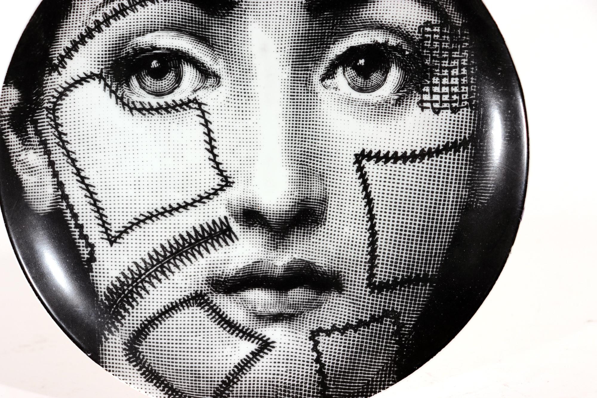 Vintage Piero Fornasetti Themes & variation plate, #127
1970s,

The Piero Fornasetti porcelain plate in the Themes & Variation pattern depicts a surreal depiction of a woman's face as a stitched soccer ball, The face is that of Lina Cavalieri,