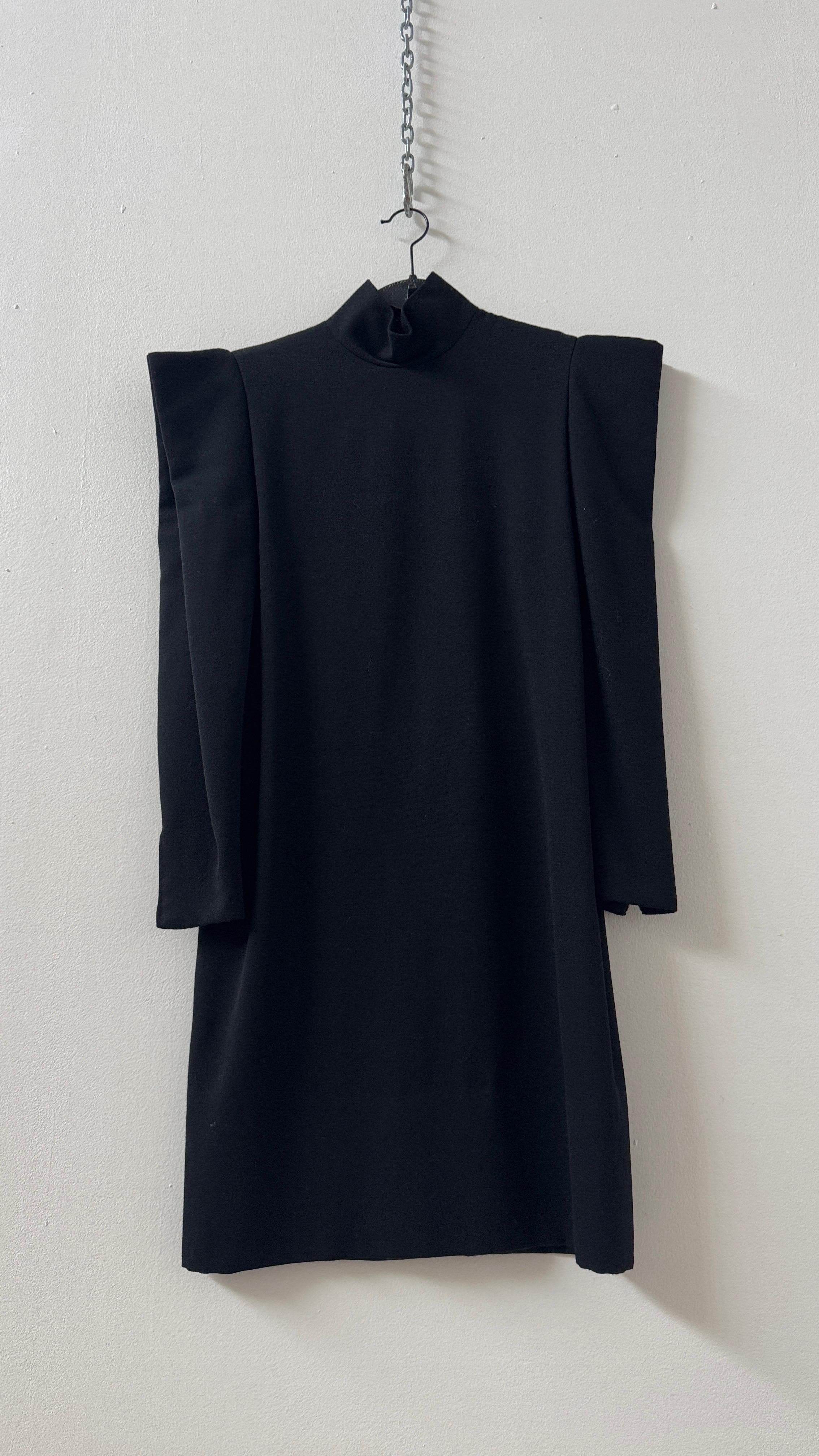 This rare vintage Pierre Cardin black dress is a stunning example of the designer’s avant-garde vision and architectural approach to fashion. Featuring sculptural, structured shoulders, this piece embodies the futuristic aesthetic that defined