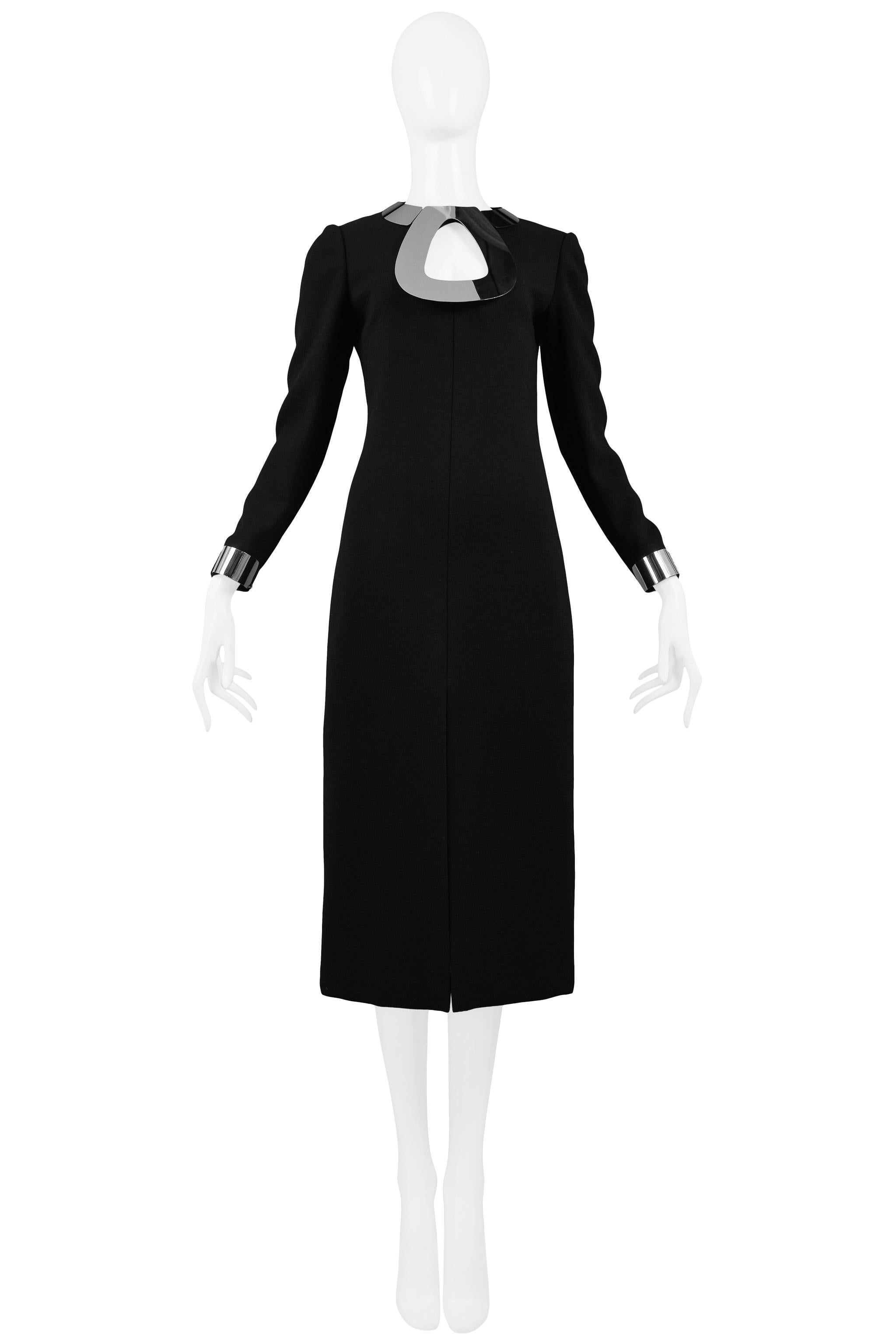 Vintage Pierre Cardin schwarzer Wolle Cocktail-Kleid, das eine Chrom-Metall-Halskette und Armband Manschetten, schlanke Körper, Mitte vorne geschlitzt, Mitte hinten Reißverschluss und unter dem Knie Länge verfügt. Circa 1968.

Ausgezeichneter