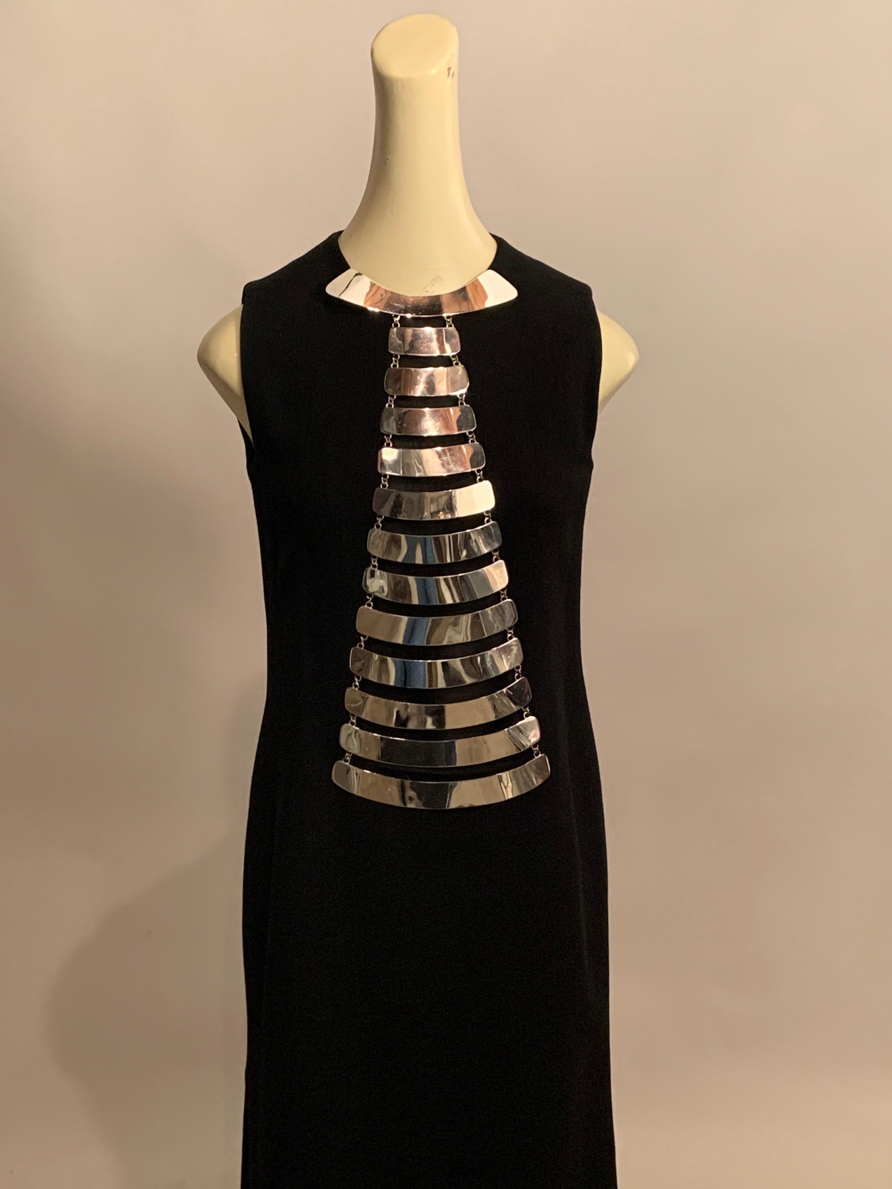 This dramatic Space Age design from Pierre Cardin looks just as fabulous today as it did in 1968.  The sleeveless black wool dress has a round neckline, two generous side openings, and a center back invisible zipper. This creates the perfect