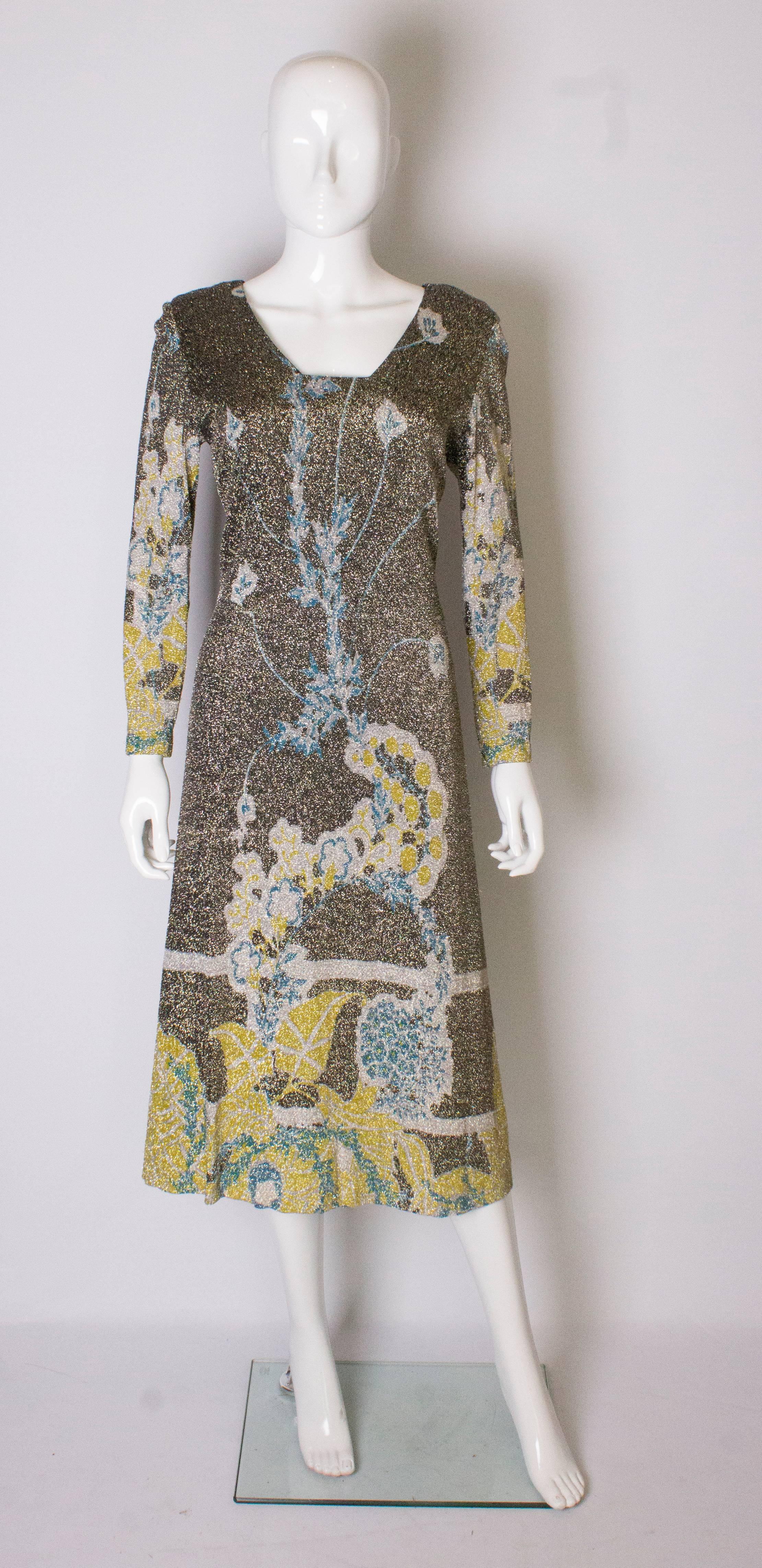 A sparkly vintage dress by Pierre Cardin. The dress was designed for Jersey Couture by Pierre Cardin. It has long sleeves , a flat v neckline, central back zip and is fully lined. The dress has a 2'' hem.