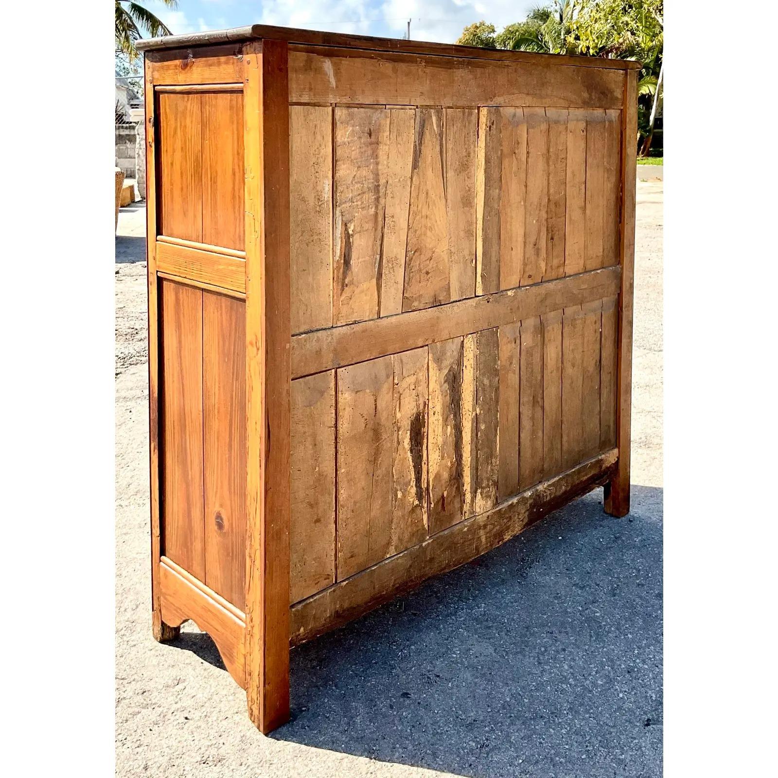 Stunning vintage hand carved storage cabinet. Purchased from the legendary Pierre Deux. A brilliant antique that they acquired in Paris. Beautiful wood grain detail and fantastic heavy hardware. Key is included. Acquired from a Palm Beach estate.