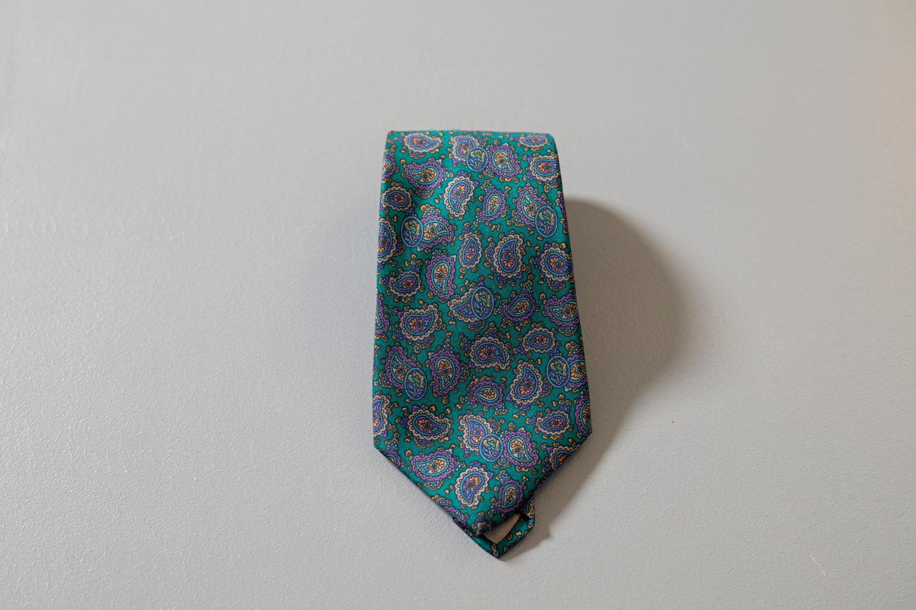 Cravate vintage Pierre Lorrain, elle est réalisée en 100% soie, avec des motifs paisley dans des tons de vert et de violet. Grâce à son motif très particulier, s'il est associé à un costume élégant, il est idéal pour un look raffiné et particulier.