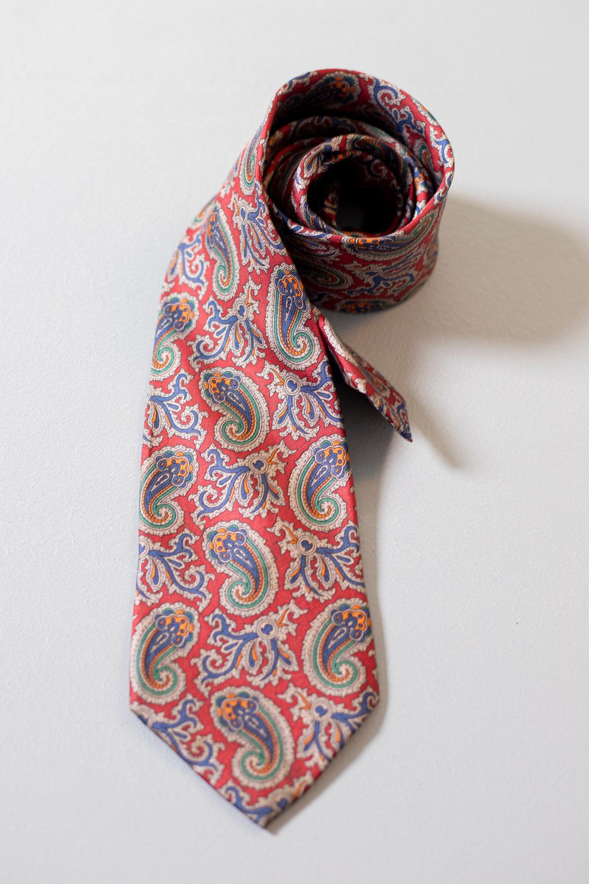 Yellow, green, blue and white motifs on a red background: this vintage tie designed by Pierre Lorraine is everything but boring. Made in silk, it is perfect both for a formal and an informal situation.