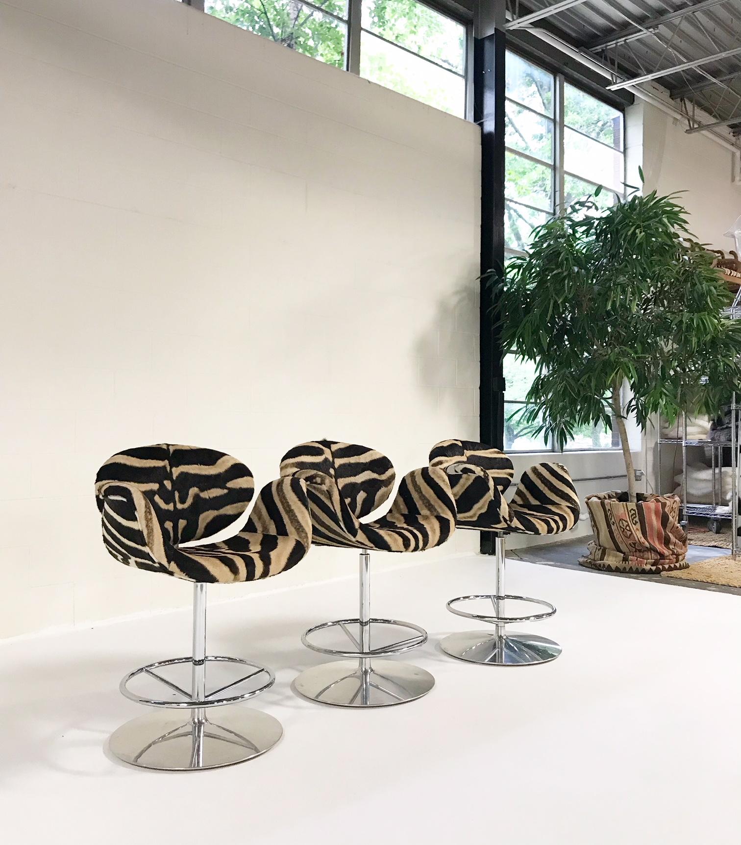 We love the design of Pierre Paulin's little Tulip bar stool! Paulin was inspired by the simplicity of the tulip flower as it spreads its half-open petals. The curved arms of the stool are held by the chrome back and tubing that supports them,