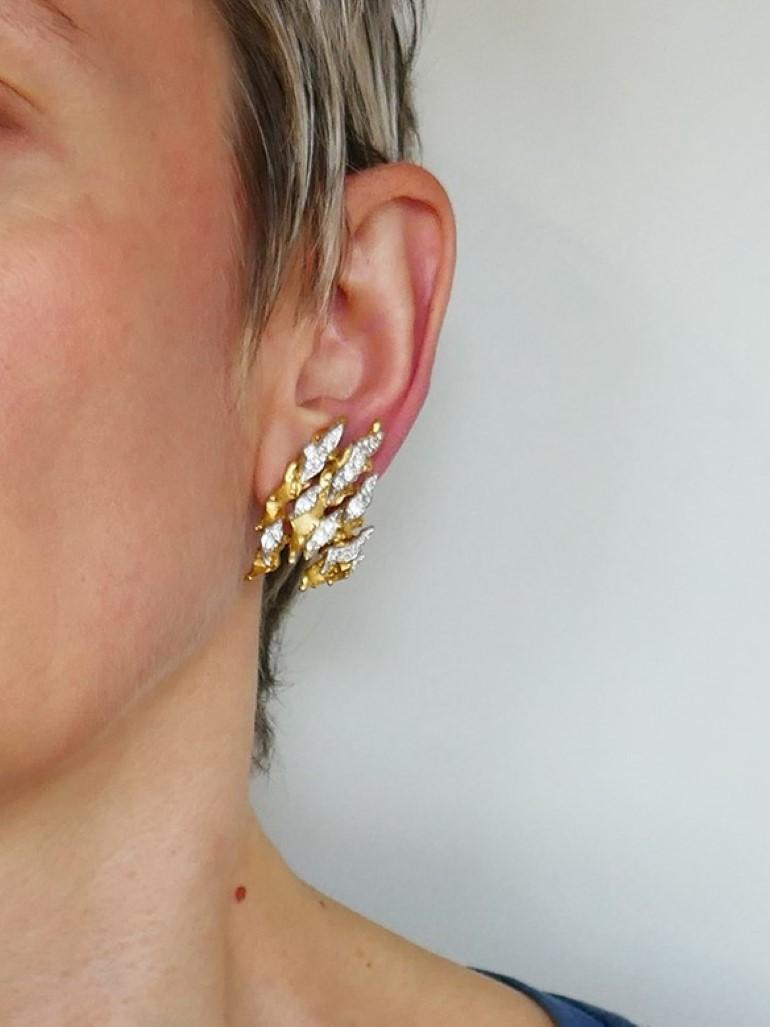 Ein exquisites Paar Vintage-Ohrringe von Pierre Sterlé. Die Ohrringe sind aus 18 Karat Gelb- und Weißgold gefertigt und mit Diamanten besetzt.
Das abstrakte und auffällige Design der Ohrringe wurde durch verschiedene Goldschmiedetechniken erreicht,