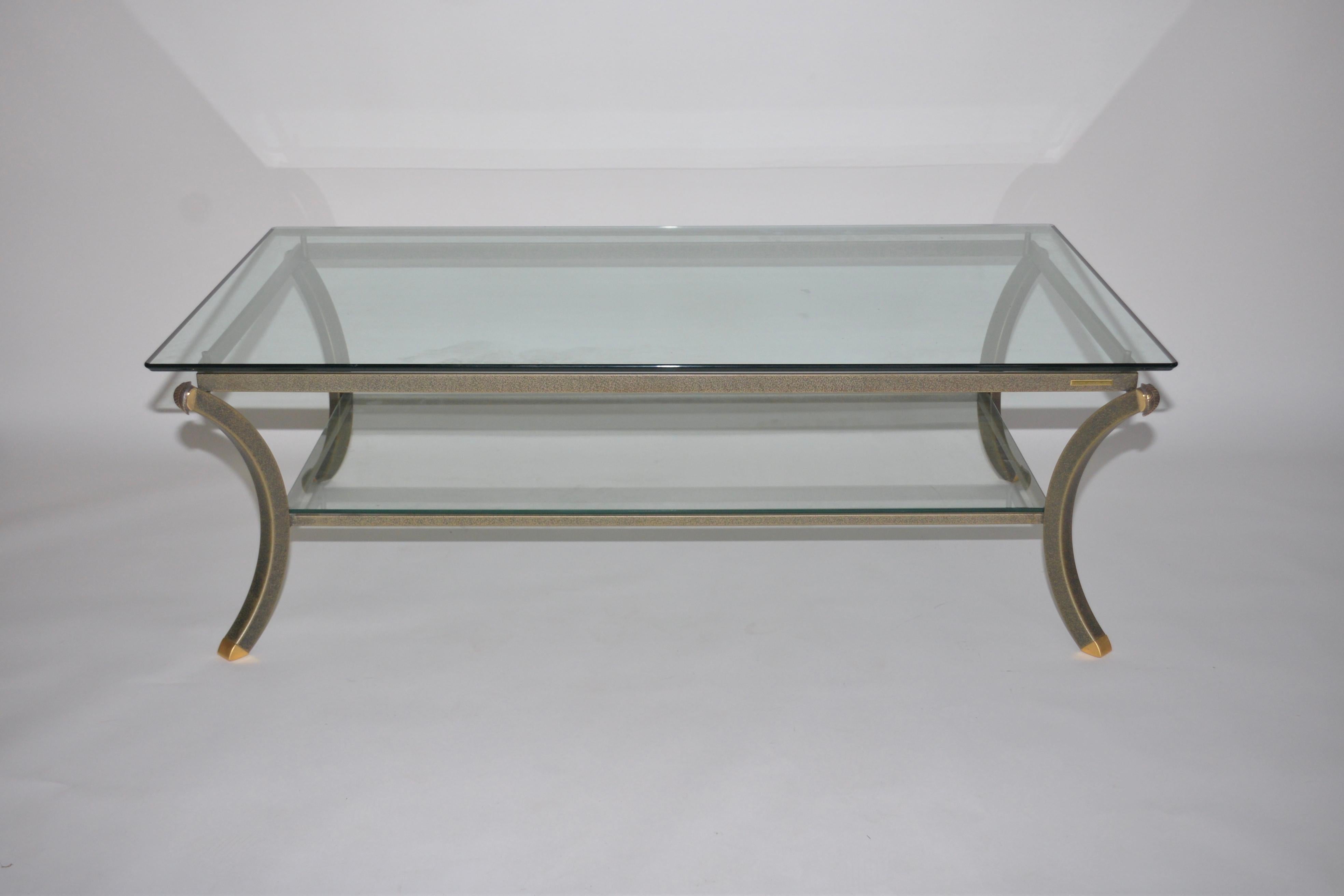 Vintage midcentury coffee table from the Villa d' Este collection from the iconic French designer Pierre Vandel. Light brown and light gold fleck in color with pretty brass leaf style motifs on each corner. There are two shelves and top shelf is