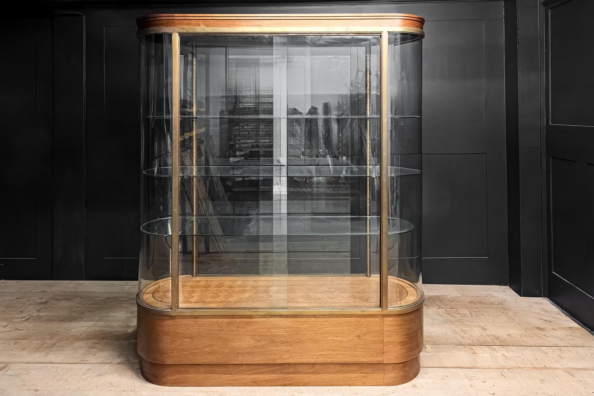 Wonderfully rare survivor of the retail display era of the 1920's. This vintage pill shaped bow ended display cabinet offers 360 degree glazing giving the perfect vista from all angles with sliding doors both sides. Came form a jewellers originally