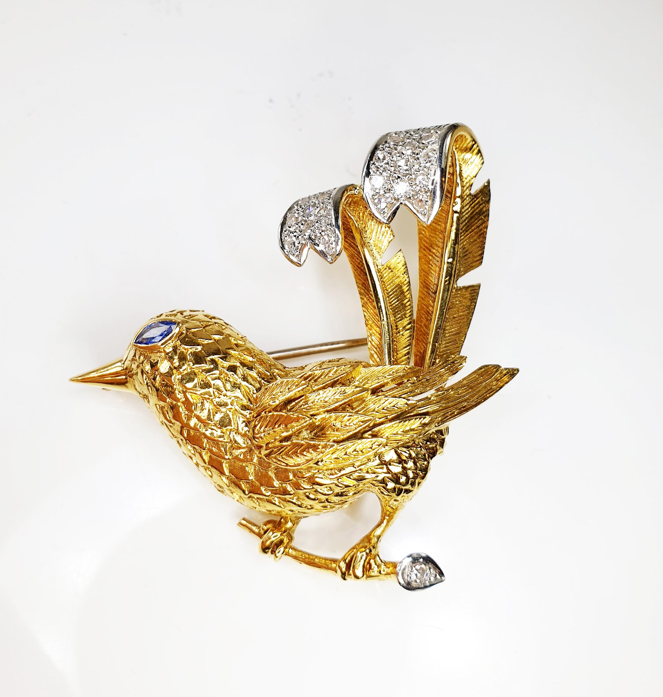 Delicate vintage pin brooch in the shape of a bird pearched on a twig. 
Chiseled in yellow gold, the tail in pavè of diamonds in white gold and a Sapphire eye.

MATERIALS
◘ Weight 14.9 grams 
◘ Size 47mm  / 1.85 inches 
◘ Diamonds aprox 0.40ct 
◘