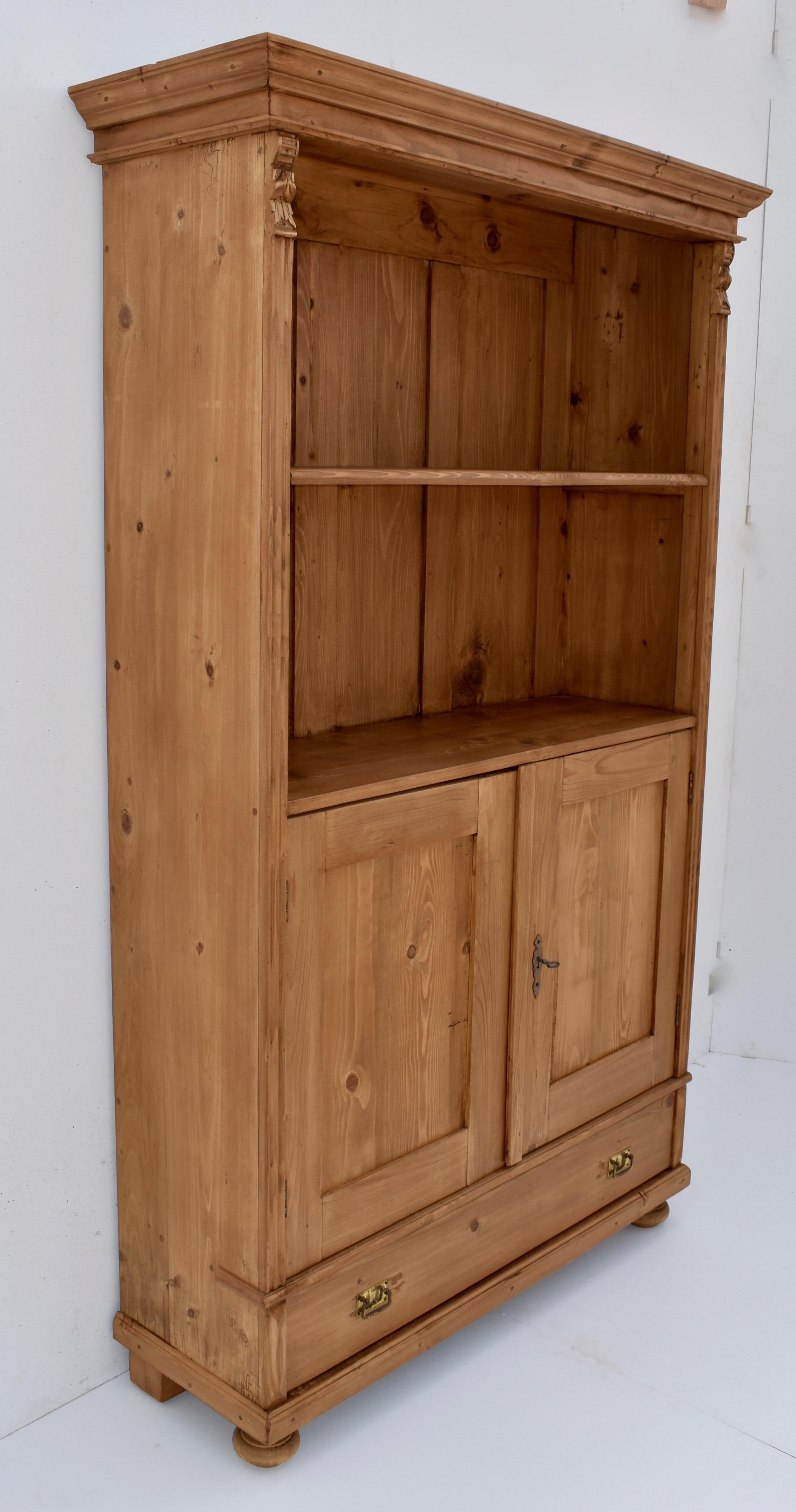 Antique pine bookcases are hard to find so the shell of this piece was provided by a plain vintage armoire. With one board width removed from the sides and the original backboards and crown molding retained; with the doors cut down, and the drawer