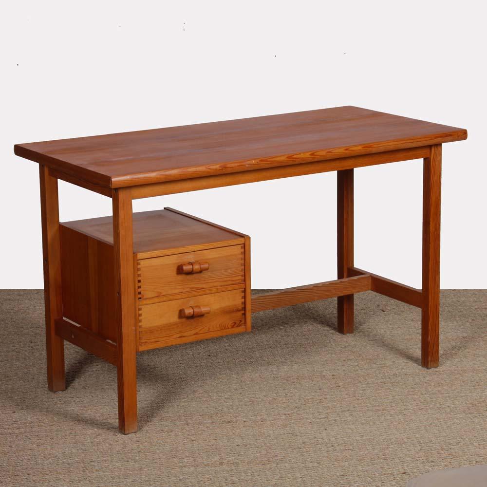 This vintage pine desk dates from the 1980s. It opens thanks to two drawers with leather handles. This table is in good original condition. The top has been restored.